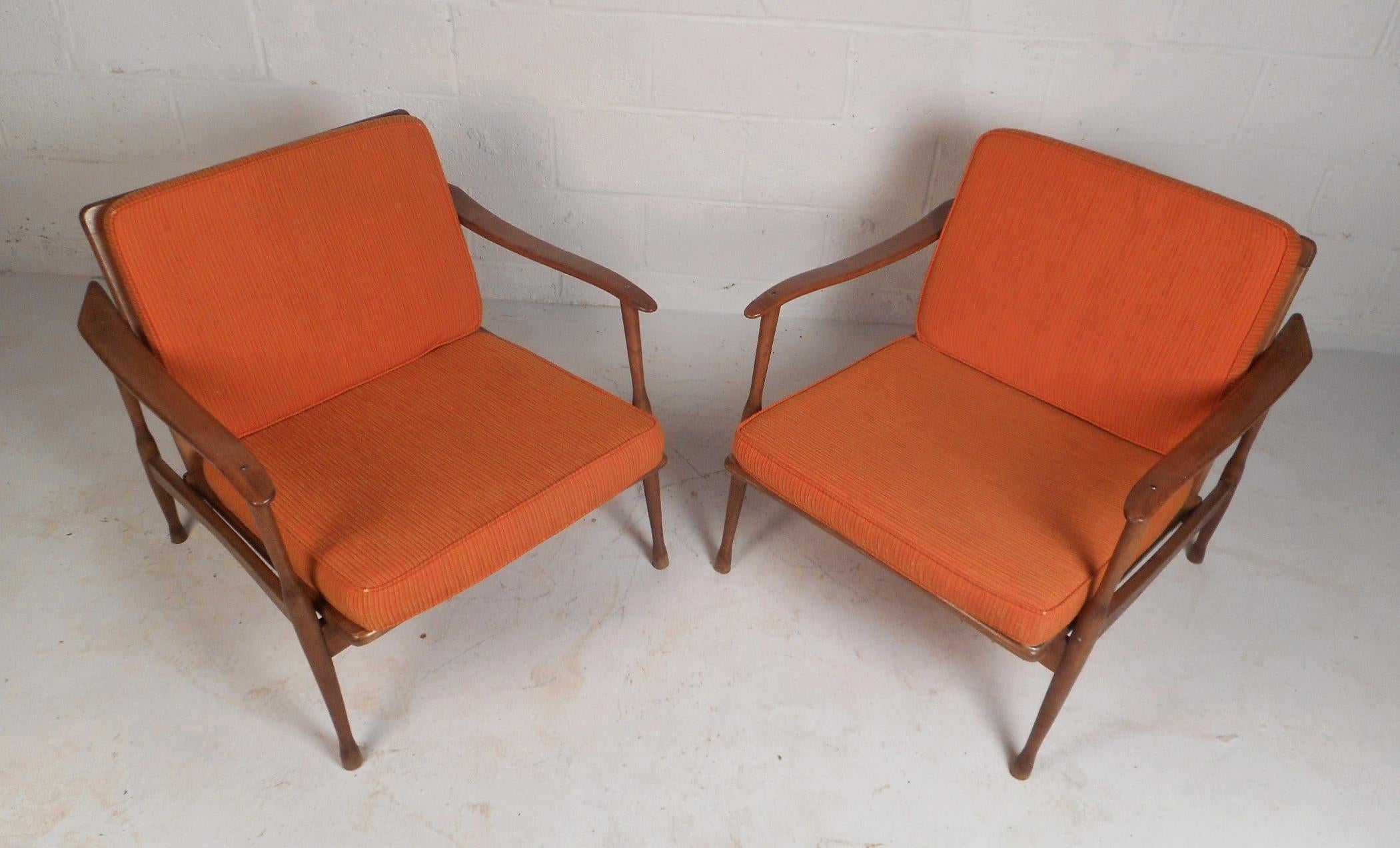 These Danish lounge chairs feature a sleek walnut frame with curved arm rests and smooth edges that offer plenty of comfort without sacrificing style. This pair of midcentury chairs feature tapered legs that end at sculpted feet for a stable