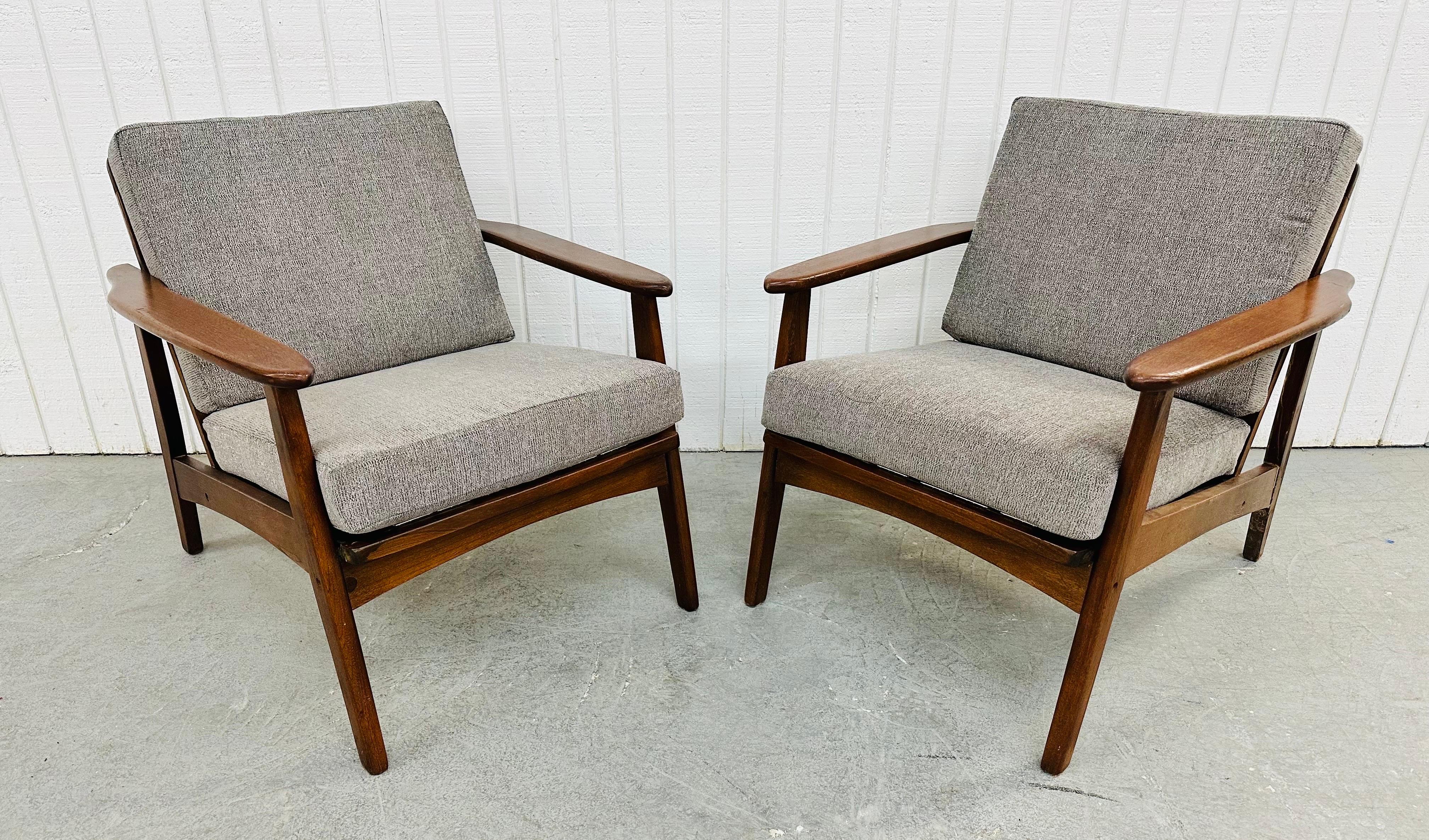 This listing is for a pair of Mid-Century Modern Walnut Lounge Chairs. Featuring solid wood walnut frames, newly upholstered gray cushions, and a spindled back design. This is an exceptional combination of quality and design!