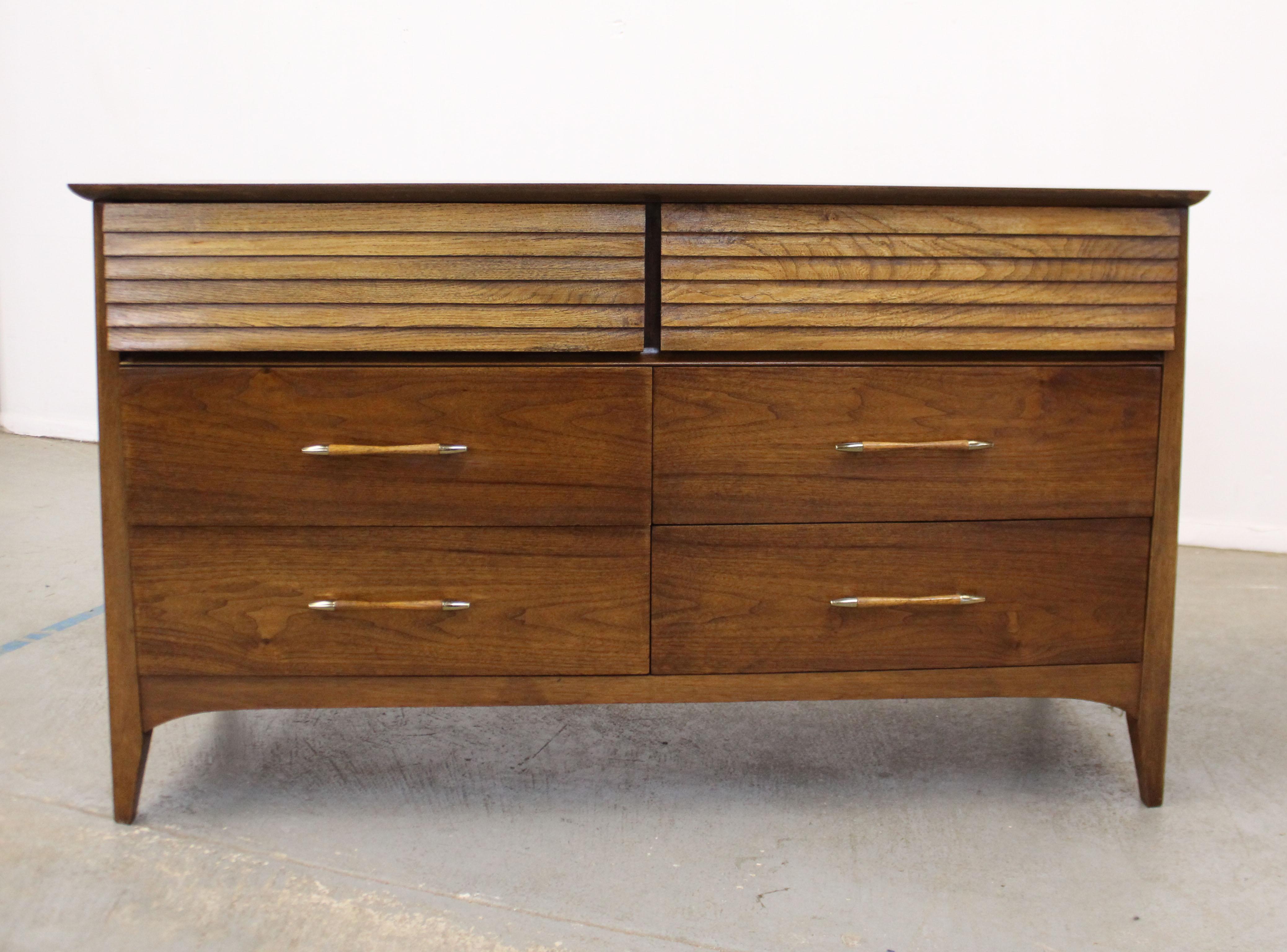 Offered is a vintage Mid-Century Modern walnut credenza. Features two top drawers with louvered fronts and 4 bottom drawers, all dovetailed. It is in excellent condition, has been refinished with minor surface wear. Some minor age wear on pulls. It
