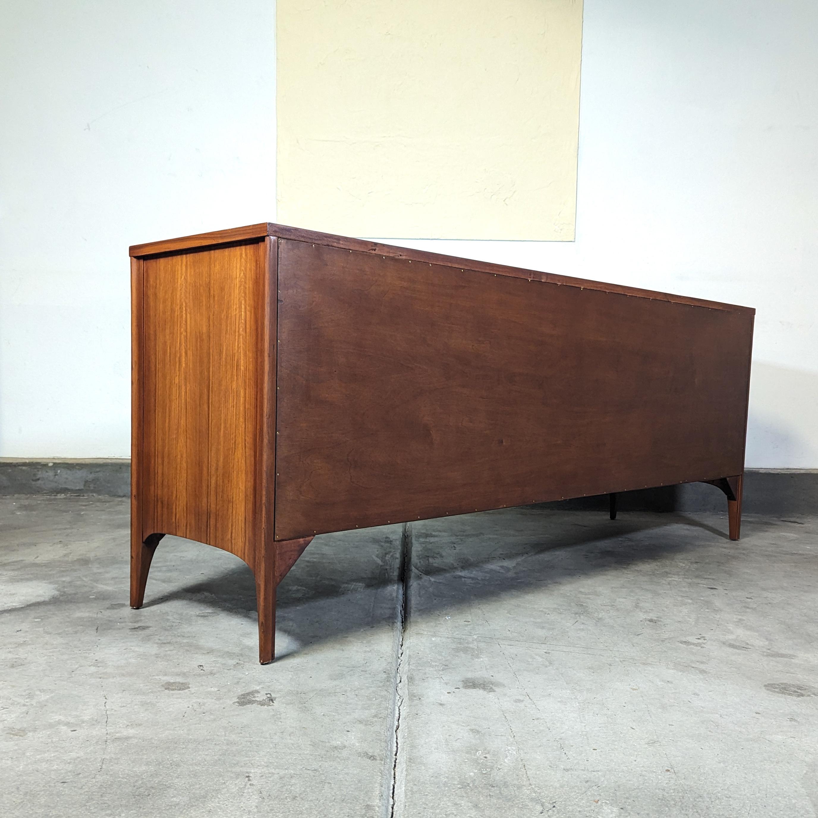 Step into the world of mid-century elegance with this exquisite Kent Coffey Lowboy Dresser from the Perspecta line, circa 1960s. Masterfully restored to its original splendor, this piece radiates sophistication and charm, boasting an expansive form