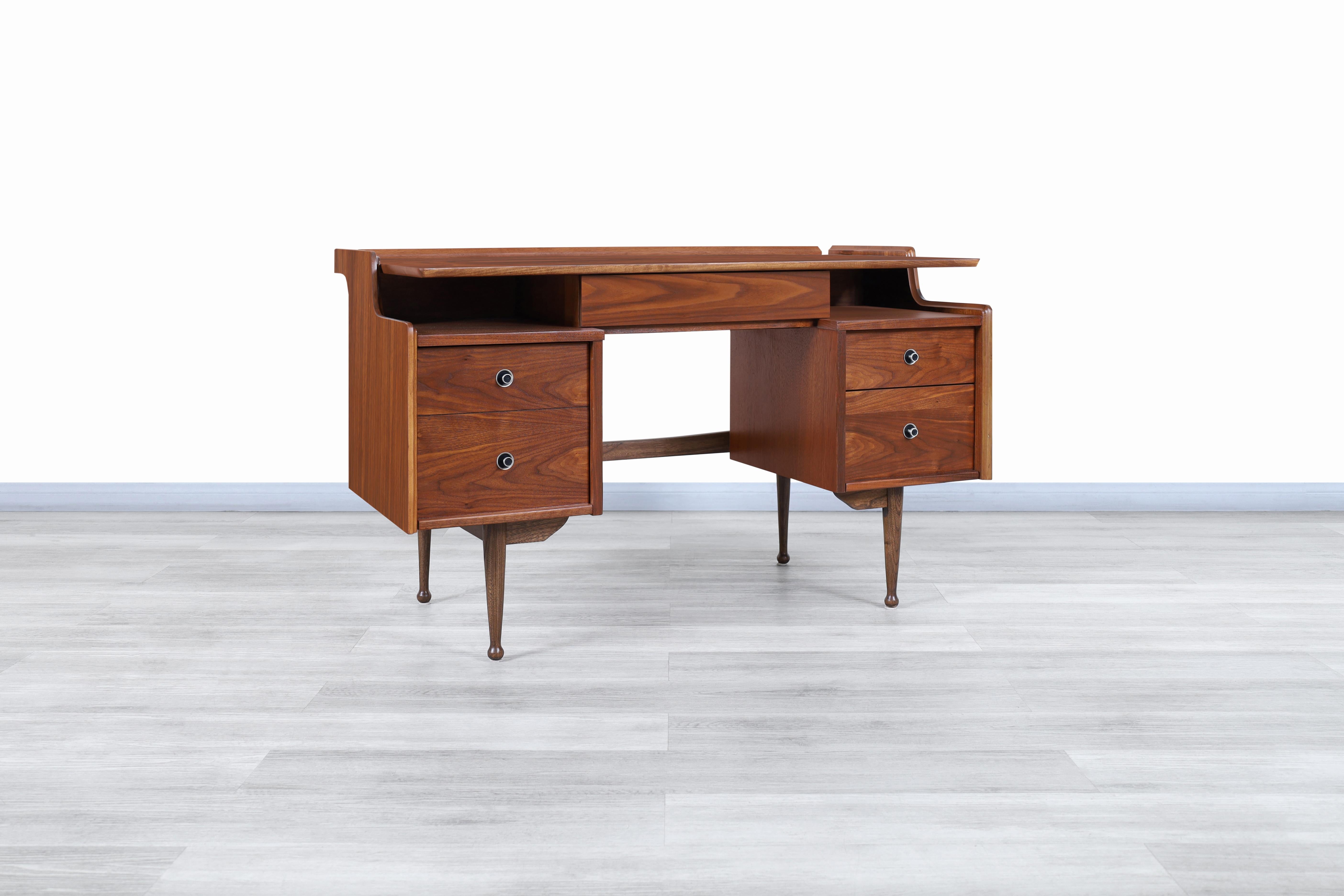 Fabulous Mid-Century Modern walnut “Mainline” desk by Hooker Furniture in the United States, circa 1960s. This desk has been built from the highest quality walnut wood. It has a design that focuses on offering a pleasant user experience but stands