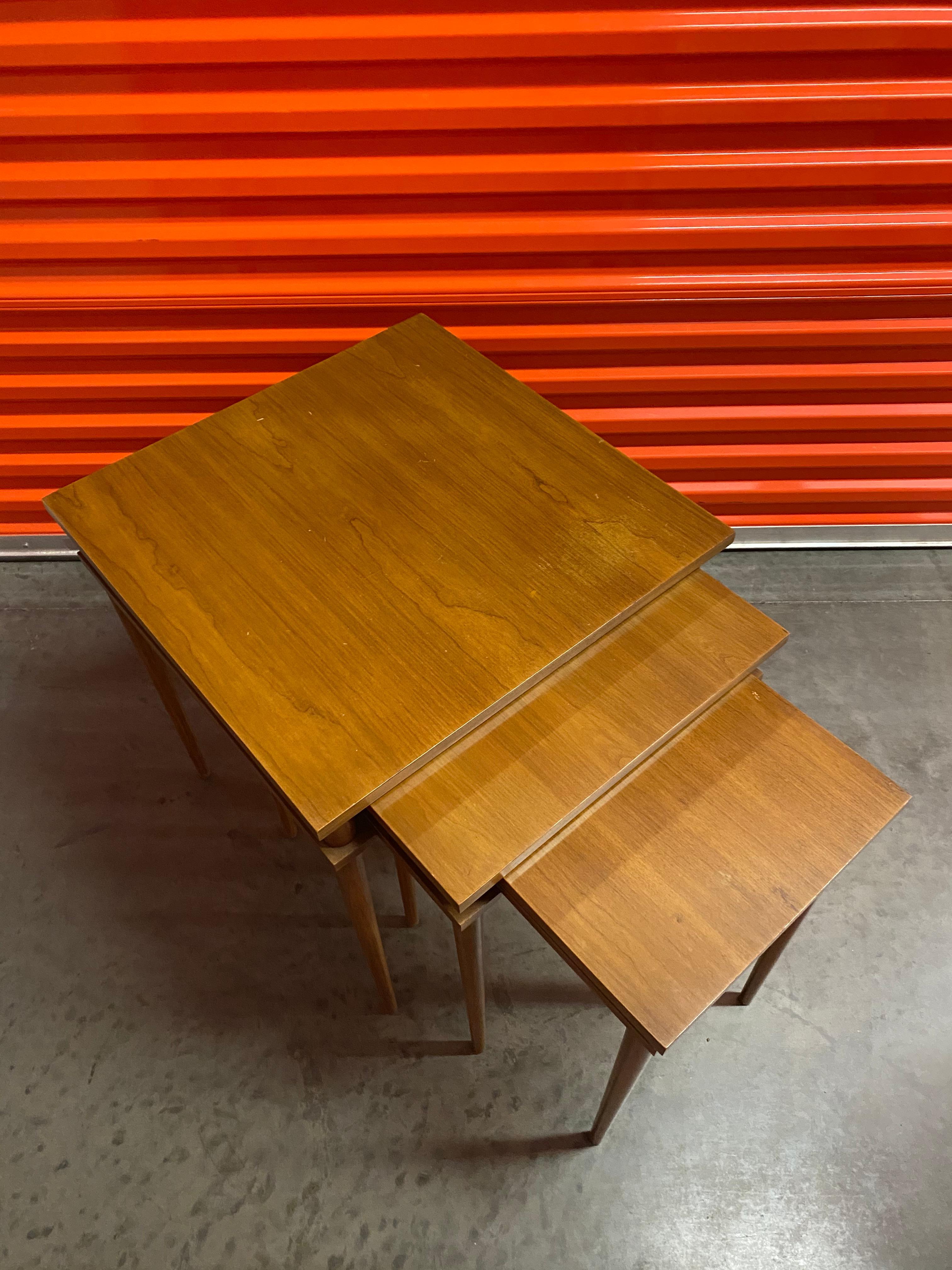 Set of three Mid-Century Modern nesting side tables by John Widdicomb (Co.). Tapered legs and rectangular shape. Beautiful walnut wood grain. Tables nest together under the footprint of the largest table.

Made by John Widdicomb Co., Grand Rapids,