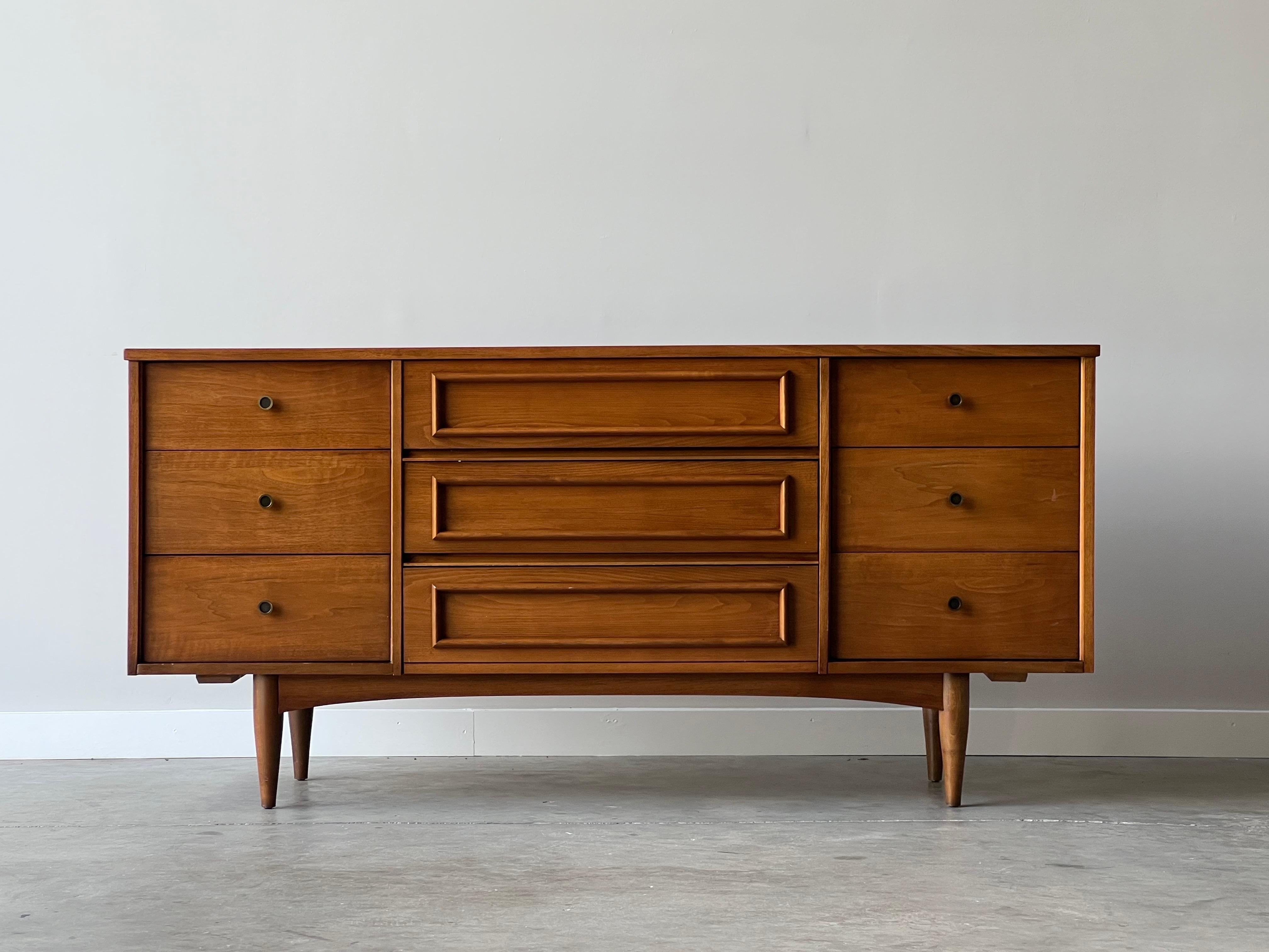 Mid century modern walnut 9 drawer dresser with wonderful details throughout. Brass and black enamel circular pulls, tapered legs, arched base, and sculpted bordered middle drawers. There’s not much to not love. Recently refinished and only showing