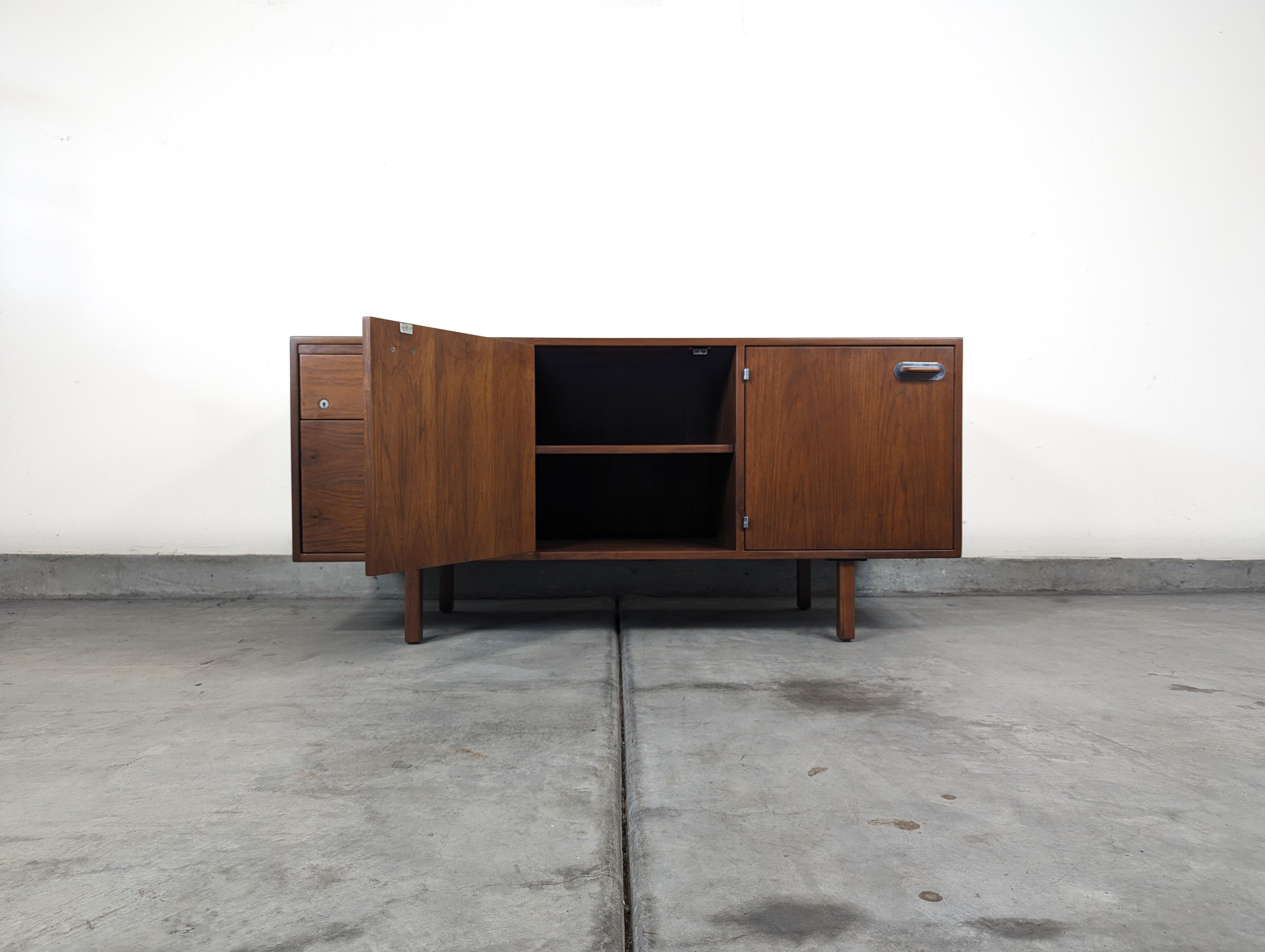 Step back in time and enhance your workspace with the sophisticated elegance of this Vintage Mid Century Modern Walnut Office Credenza, designed by the legendary Danish-American designer Jens Risom in the 1960s. Known for his innovative designs that
