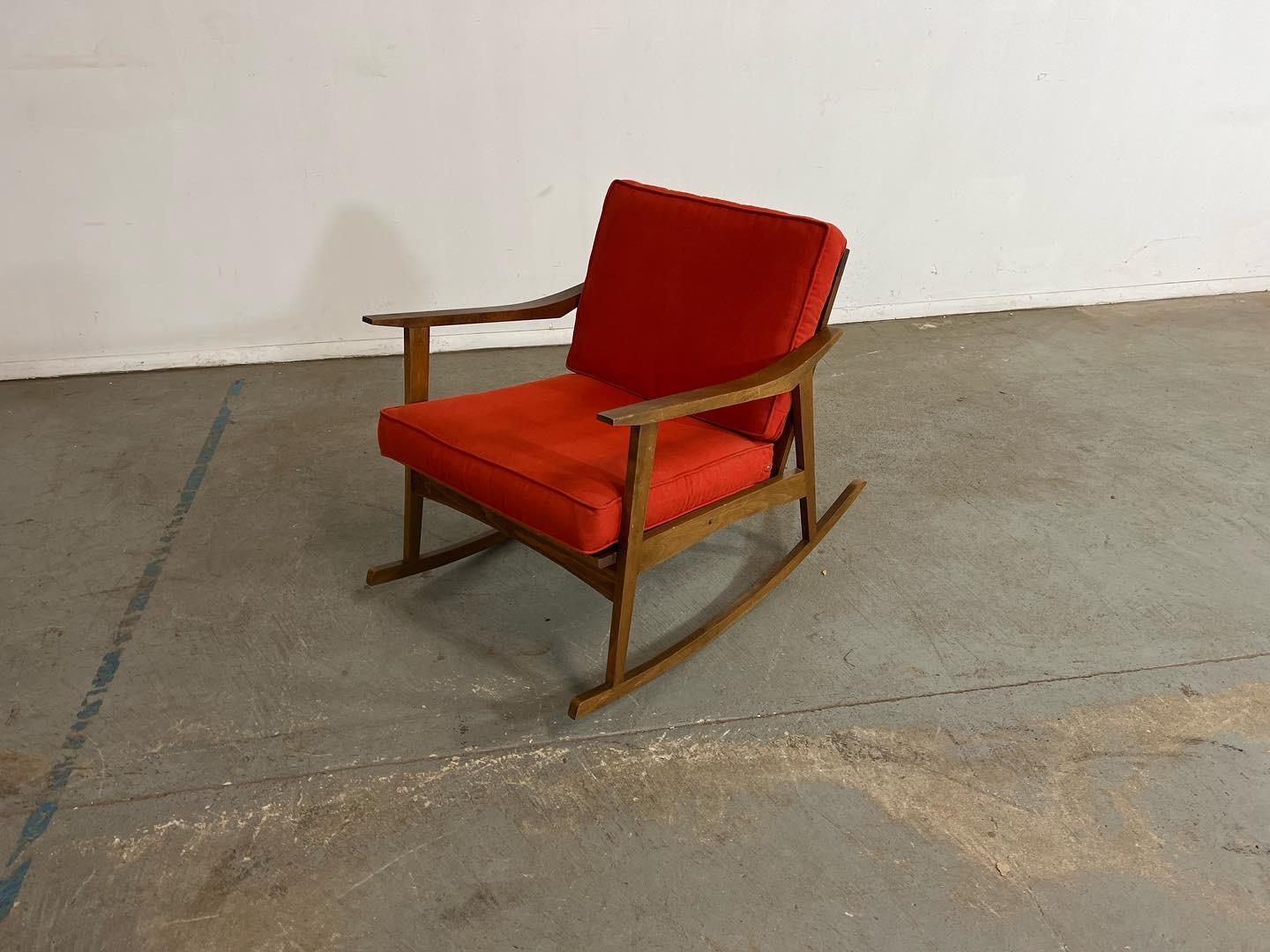 Mid-Century Modern walnut open arm rocking / lounge chair.

Offered is a mid-century modern open arm rocking / lounge chair. This piece is made of walnut and has been upholstered with textured Orange fabric. It is in good condition for its age