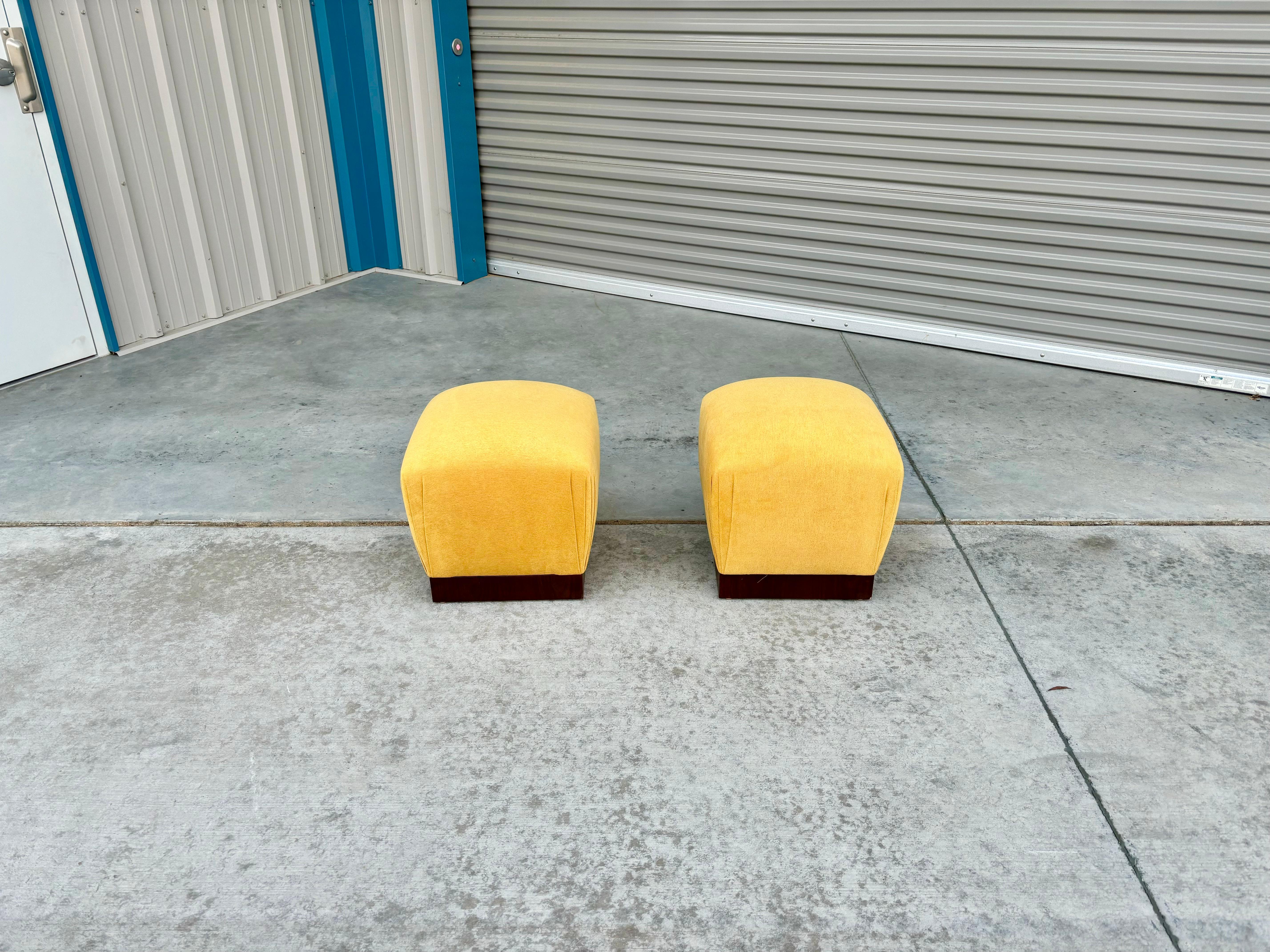 Pair of mid-century walnut ottoman designed and manufactured in the United States circa 1970s. These ottomans feature a sleek and sturdy walnut frame that perfectly complements the vibrant yellow upholstery. Whether you're looking to add a pop of