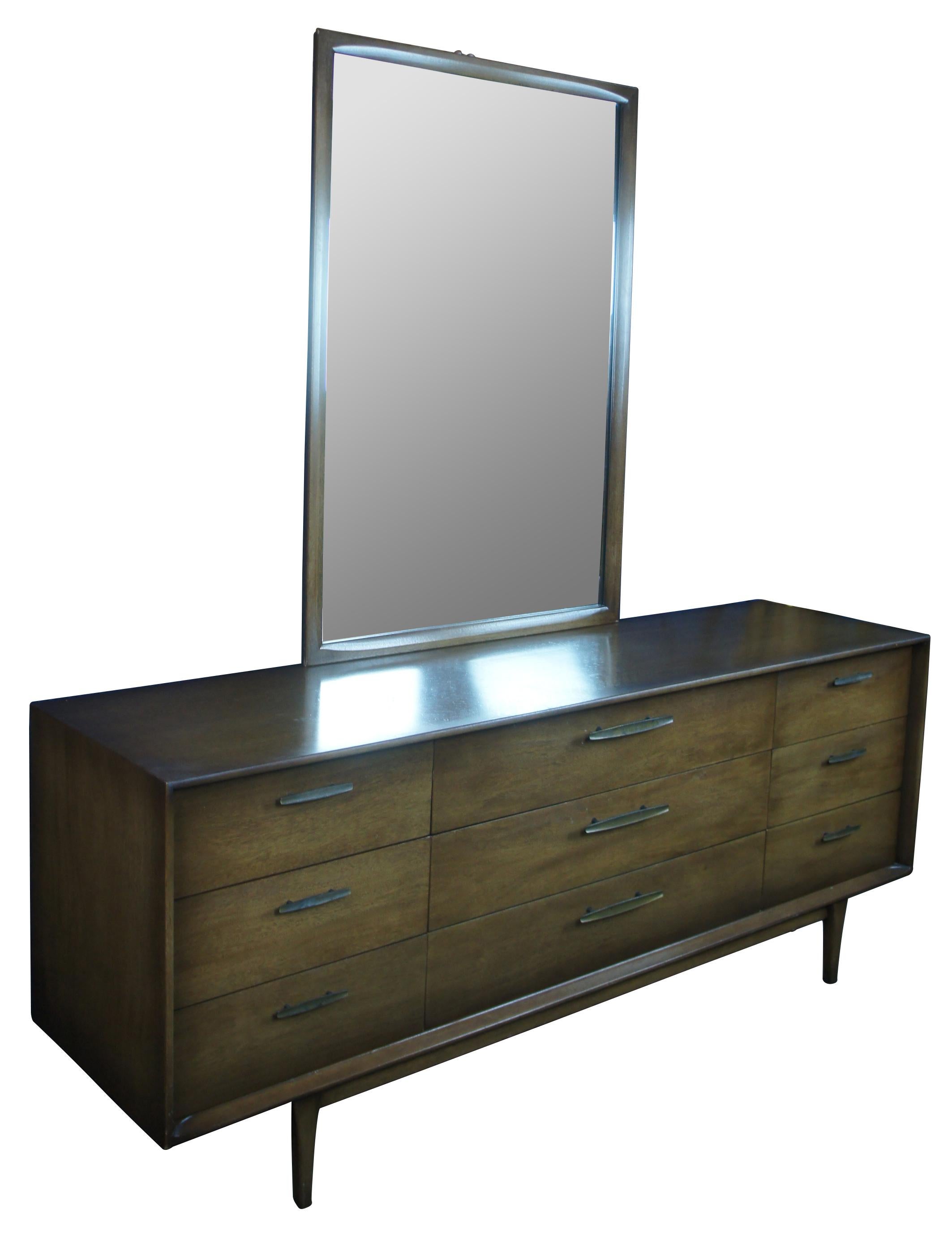 Mid-Century Modern mirrored dresser. Made of walnut featuring rectangular form with nine drawers supported by tapered legs.

Measures: dresser 31