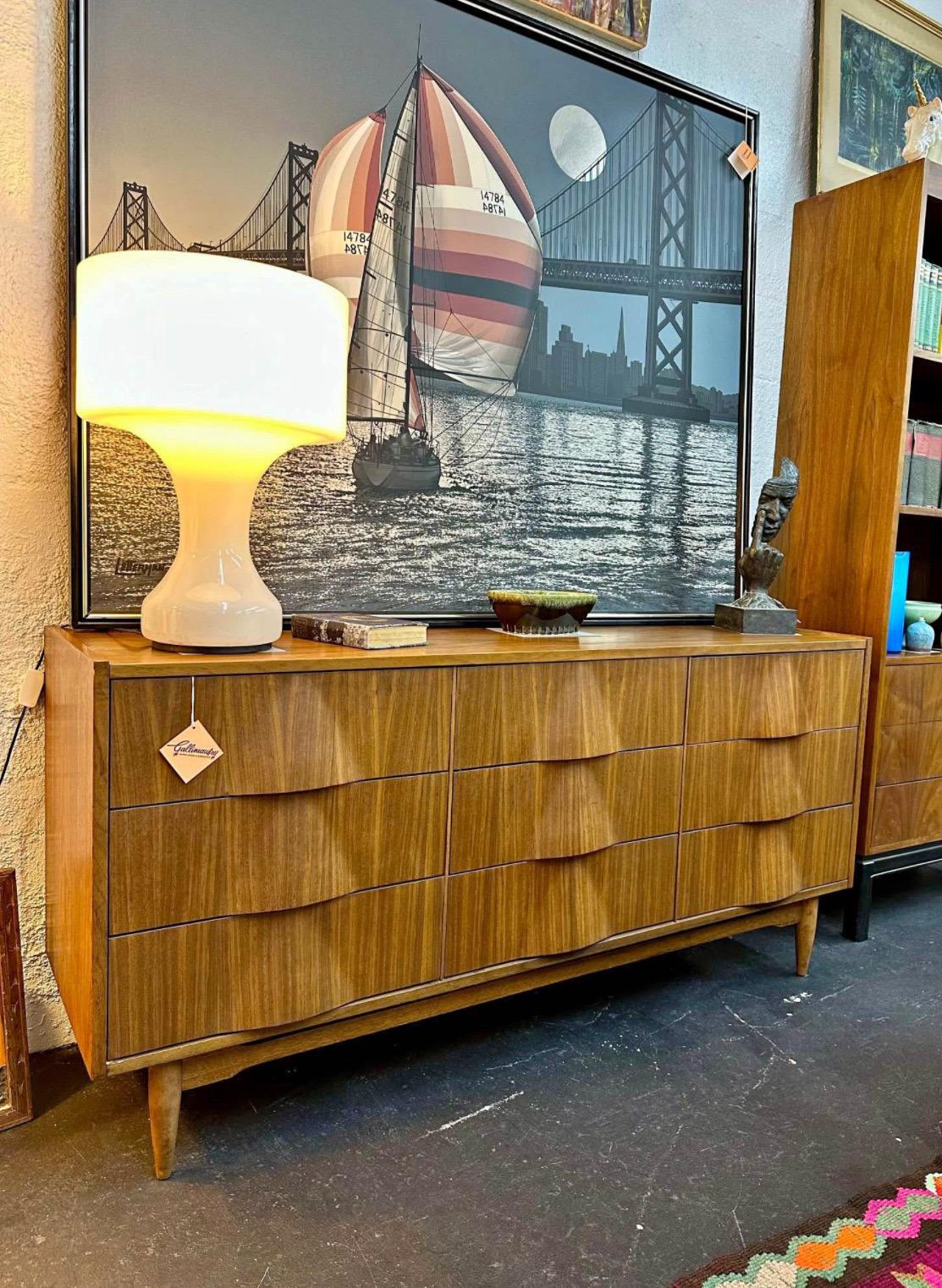 Mid Century Modern Walnut long nine drawer dresser circa 1960’s with molded triangular convex fronts. Great clean modernist lines. Maker unknown, but a solid well built piece. In good original vintage condition some typical cosmetic wear such as