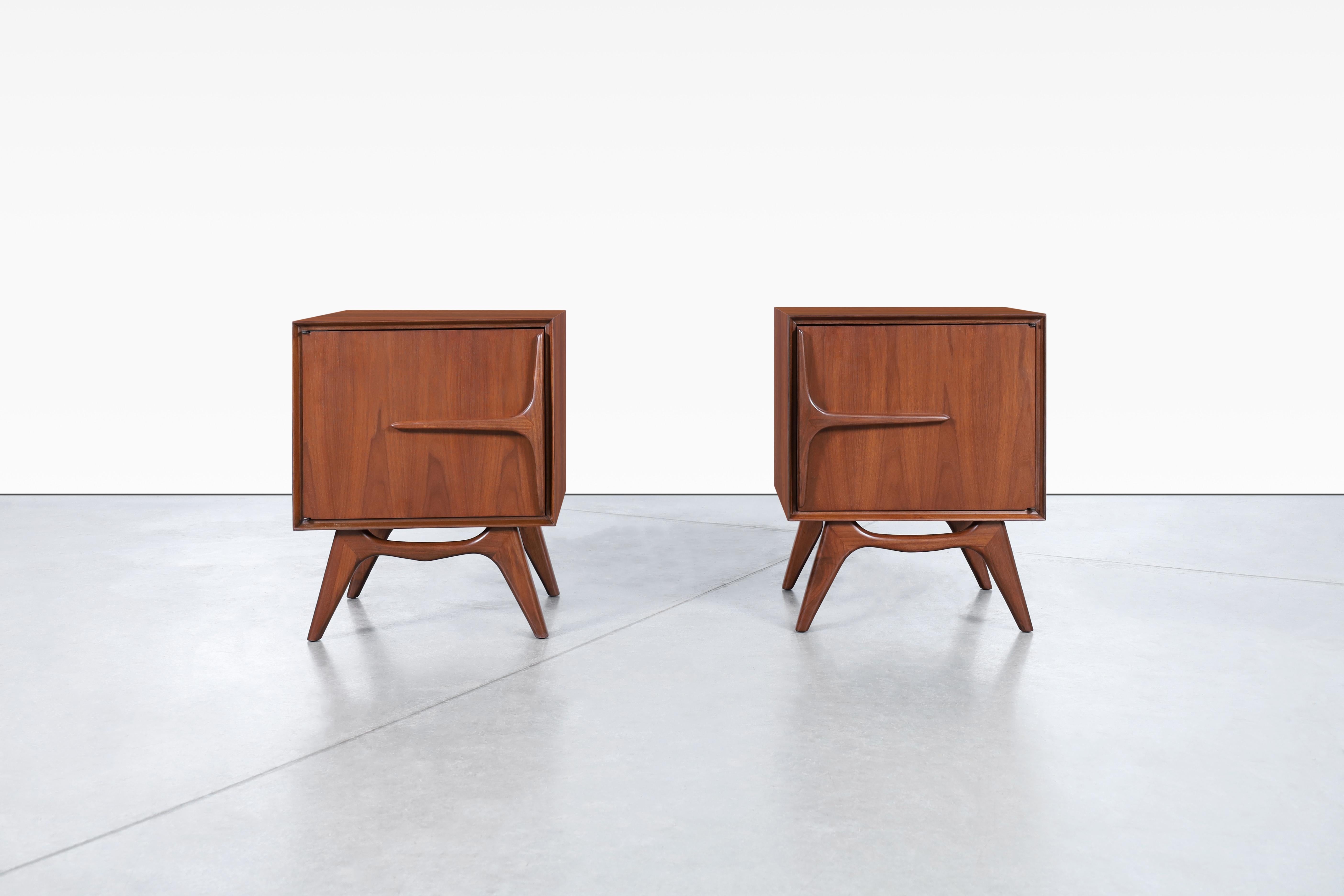 Beautiful mid-century modern walnut sculptural nightstands, produced in the United States, circa 1950s. These nightstands are truly exceptional pieces, handcrafted from the finest quality walnut wood and boasting a daring design that is sure to