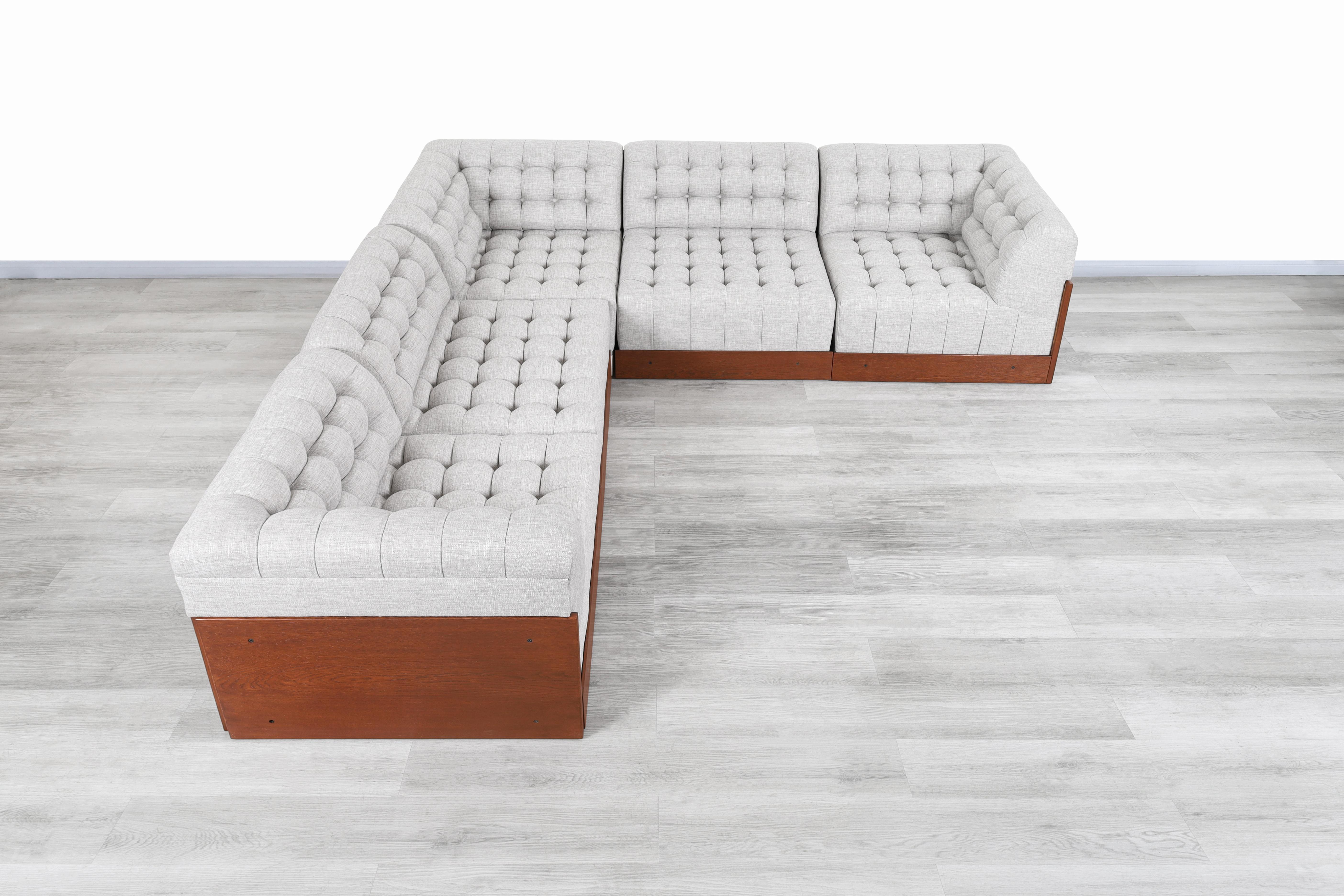 Beautiful Mid-Century Modern walnut sectional sofa designed and manufactured in the United States, circa 1960s. This sofa has a design that prioritizes space, comfort, and versatility for the user. Features ample space and can be divided into