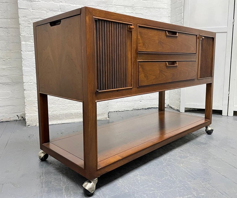 Mid-Century Modern walnut server with Warmer by Drexel. The server is walnut with two side cabinets, two pull out drawers and a warmer on top. It also extends on each side, has casters and a finished back. The warmer is in working condition.