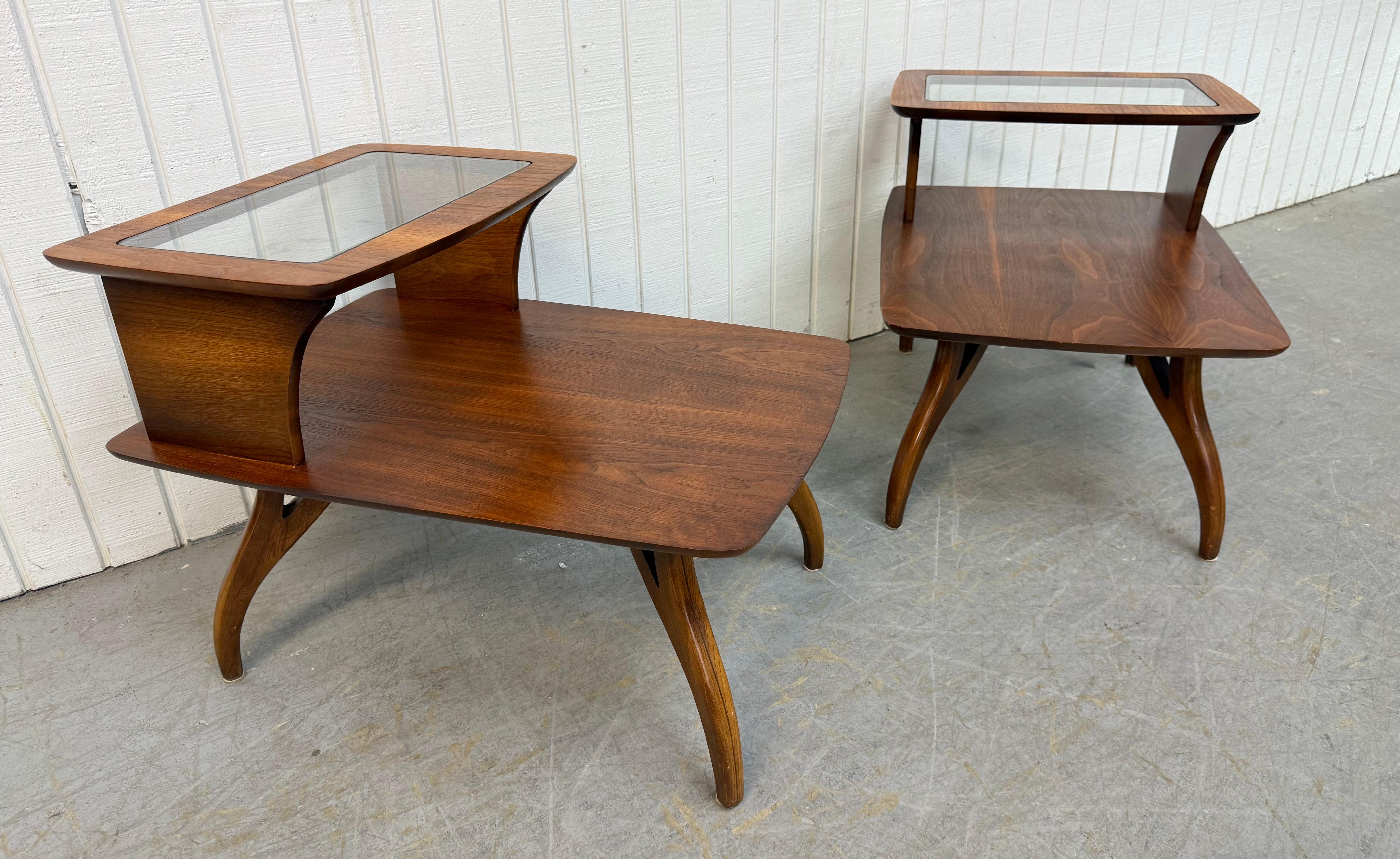 Este anuncio es para un par de mesas auxiliares de nogal modernas de mediados de siglo. Con un diseño de mesa escalonada, estante superior con inserción de cristal, patas modernas curvadas y un bonito acabado en nogal. ¡Es una combinación