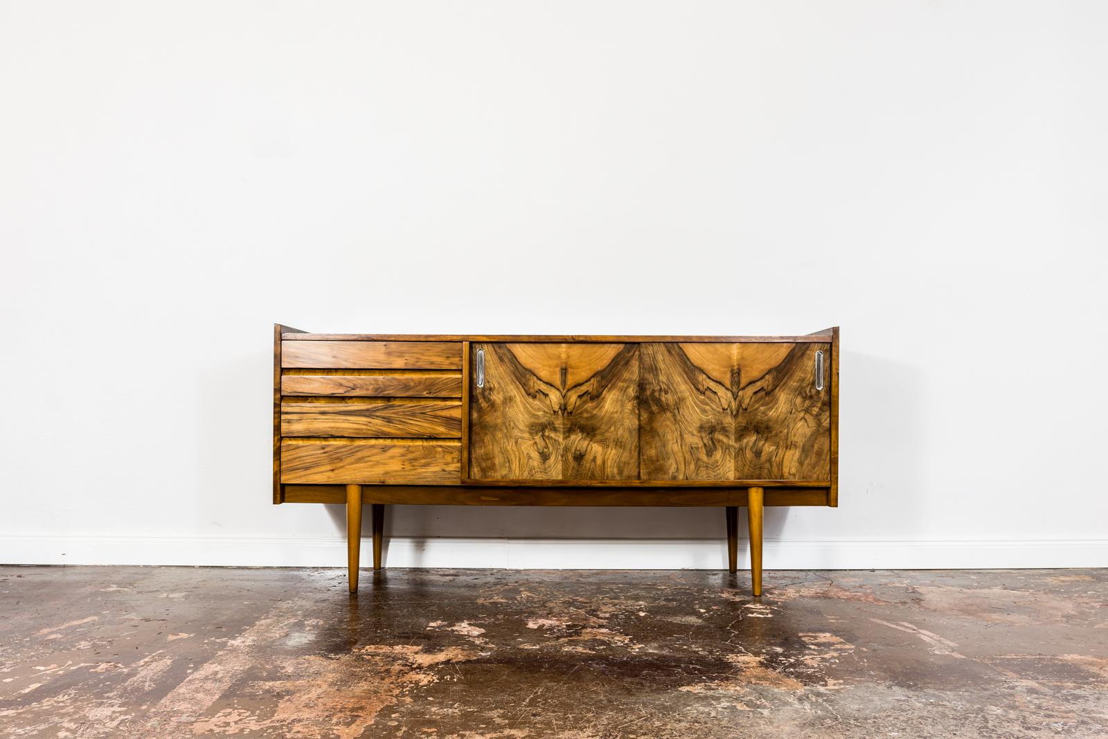 Sideboard by Slupskie Furniture Factory, 1960's, Poland.
Walnut veneer sideboard has been restored and refinished.
Case raised on solid wooden construction and legs.
Sideboard has 2 sliding doors with metal handles, 2 short removable shelves and 4