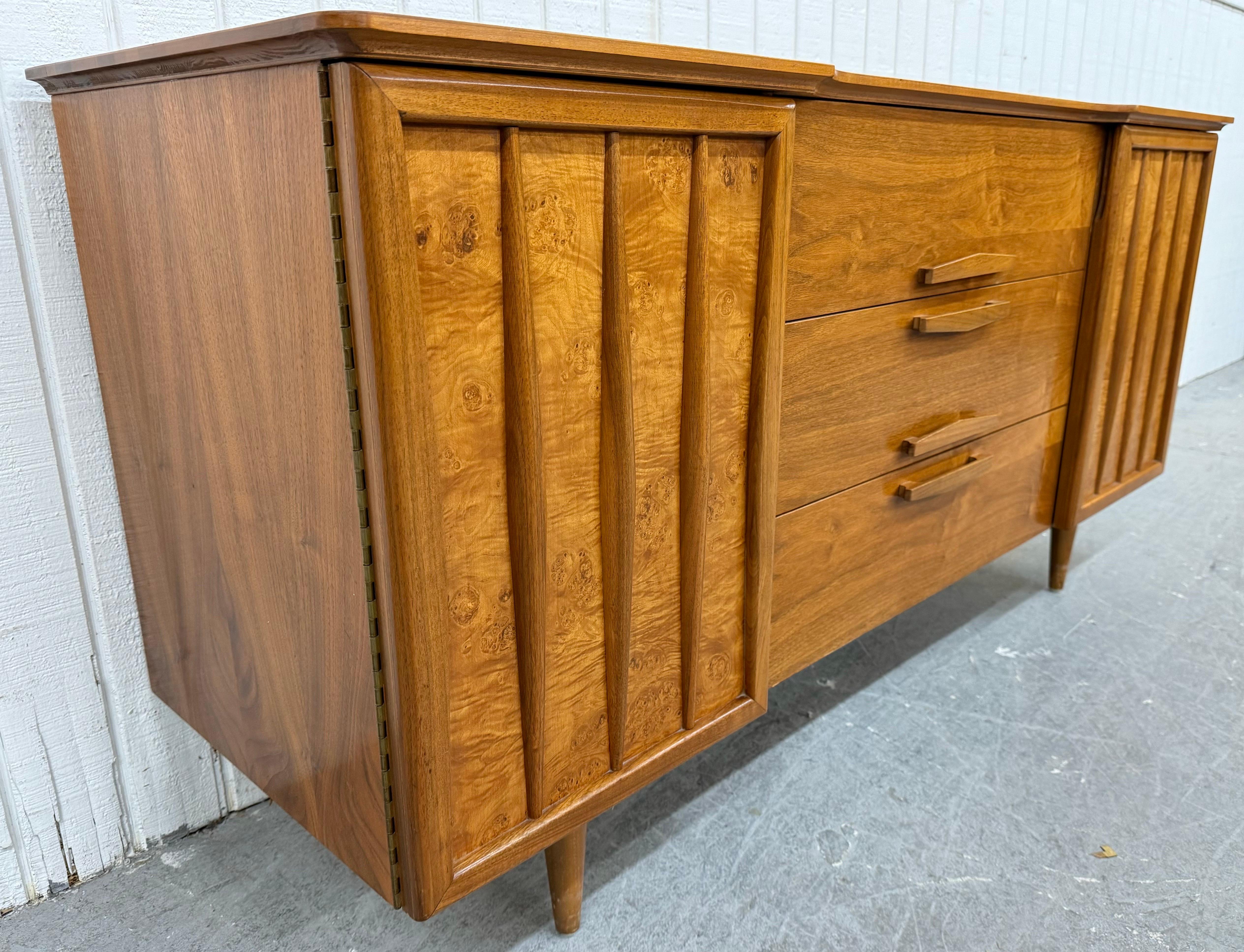 This listing is for a Mid-Century Modern Walnut Sideboard. Featuring a 1960’s design, two burled wood doors that open up to storage space, three center drawers with wooden pulls, modern legs, and a beautiful walnut finish. This is an exceptional