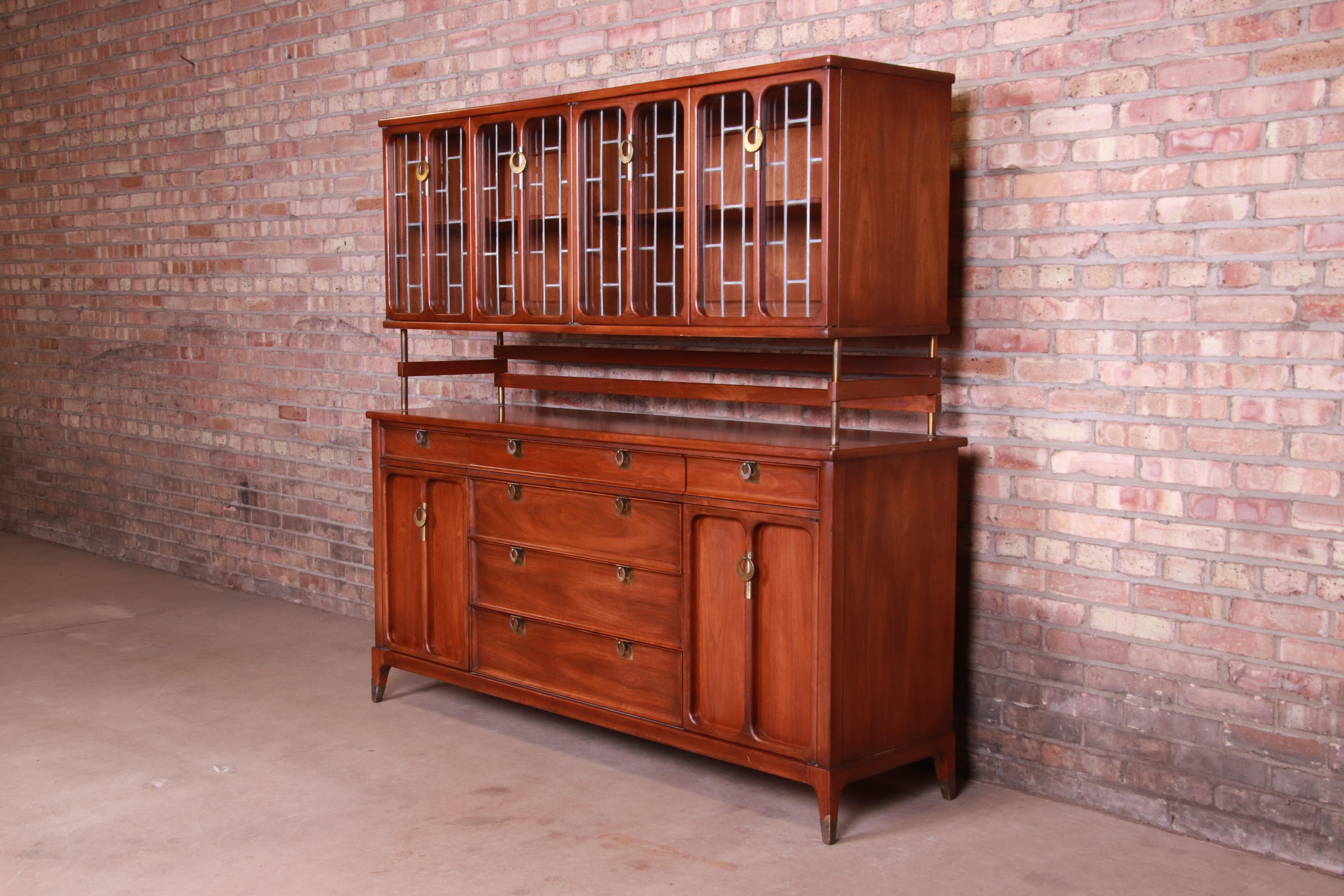 An exceptional Mid-Century Modern sideboard or bar cabinet with hutch top

By White Furniture Co.

USA, circa 1960s

Book-matched walnut, with unique leaded glass hutch top and original brass hardware.

Measures: 66.75