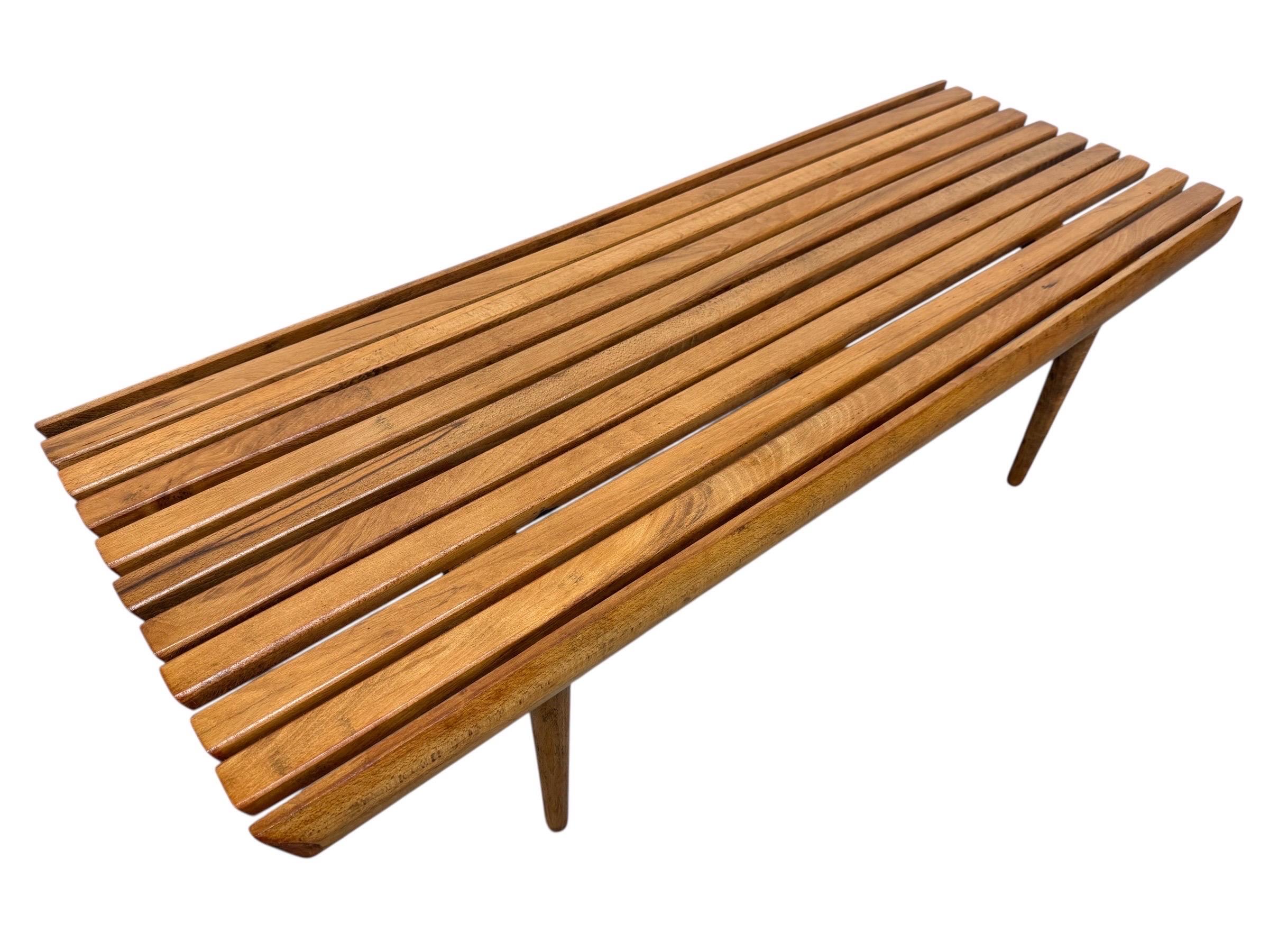 Cette annonce concerne une table basse à lattes en noyer de style moderne du milieu du siècle. Avec un design rectiligne, un plateau rectangulaire en lattes de bois, quatre pieds en bois amovibles et une belle finition en noyer. Il s'agit d'une