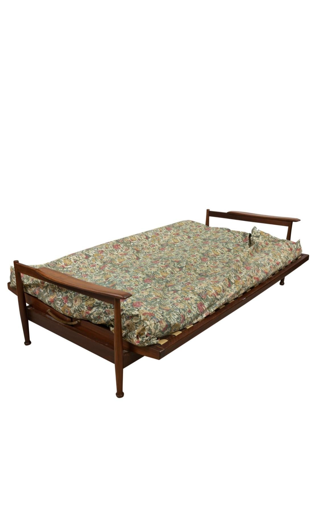 Mid-Century Modern Nussbaum Sofa Daybed mit Kissen. Sofa aus Nussbaumholz mit Paddelarmen und Messingbeschlägen für die Funktion als Tagesbett. Original-Kissen. Die Stützgurte sind beschädigt oder fehlen und müssen ersetzt werden. Solider Rahmen und