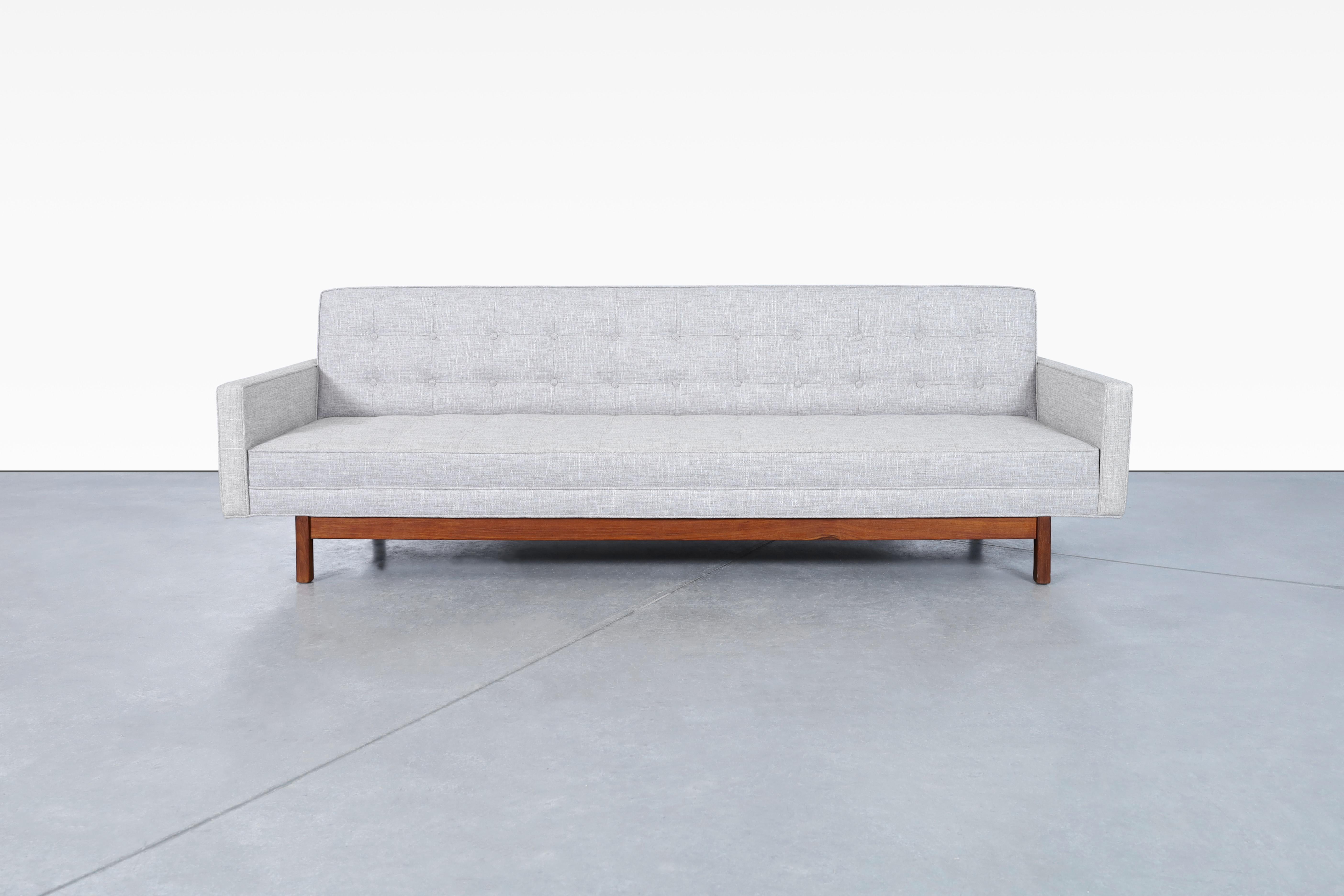Exceptional Mid-Century Modern walnut sofa designed and manufactured in the United States, circa 1960s. This mid-century sofa is the ultimate combination of comfort and style. Our professional artisans have reupholstered this piece in a shade of