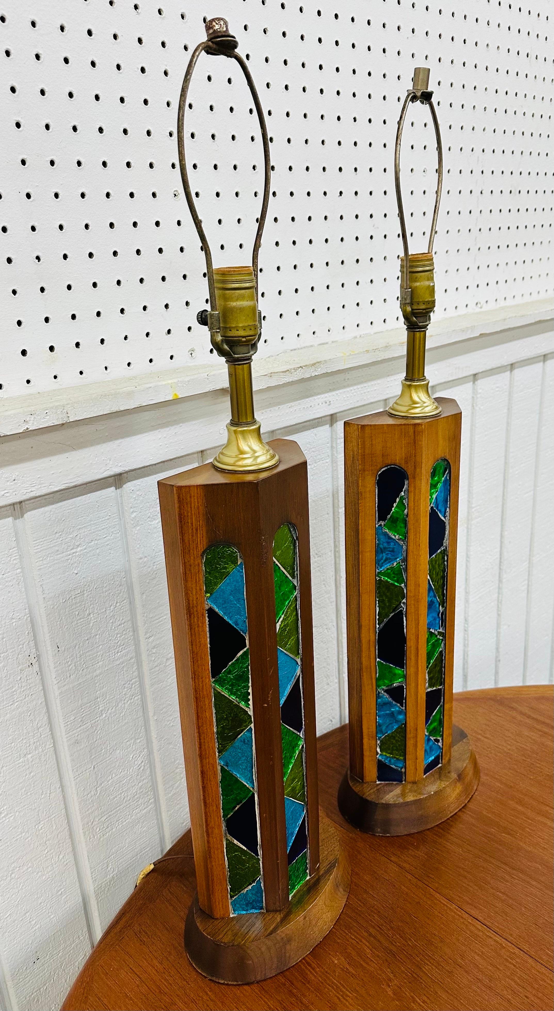 This listing is for a pair of Mid-Century Modern Walnut Stained Glass Table Lamps. Featuring a walnut base, beautiful stained glass accents, brass parts, and original cords. This is an exceptional combination of quality and design in the style of