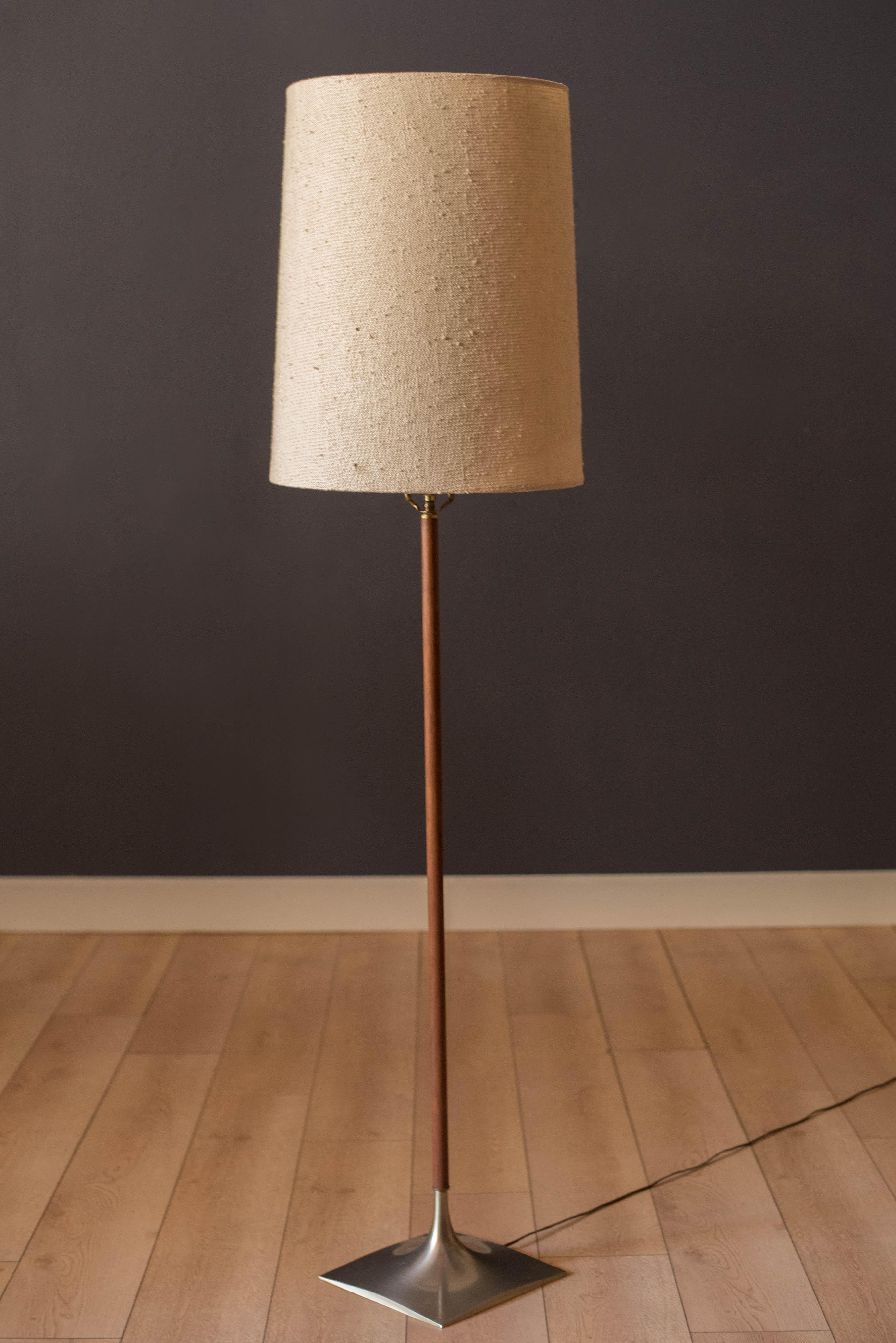 Vintage floor lamp manufactured by Laurel Lamp Co. circa 1960's. Features a walnut stem and a sculptural weighted chrome base. Functions with a three-way switch. Shade is not included. 