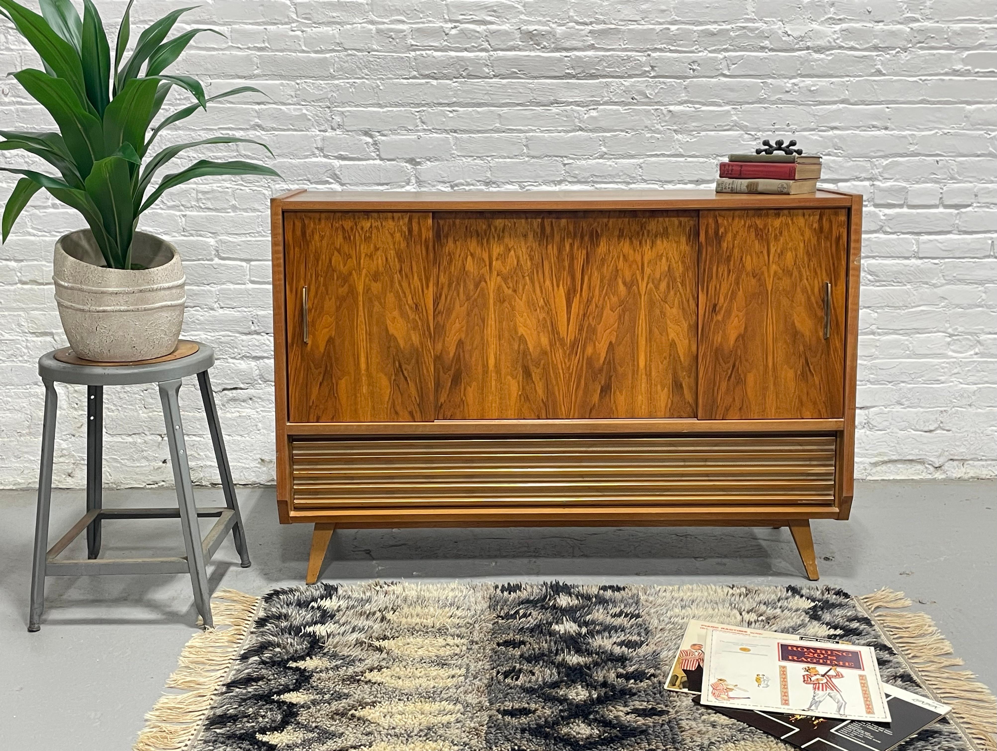 Elegant Mid Century Modern stereo console crafted in West Germany in 1959, showcasing rich walnut wood and sleek Scandinavian-inspired design. The cabinet features sliding doors with brass handles, concealing a Hymnus Hi-Fi stereo and Telefunken