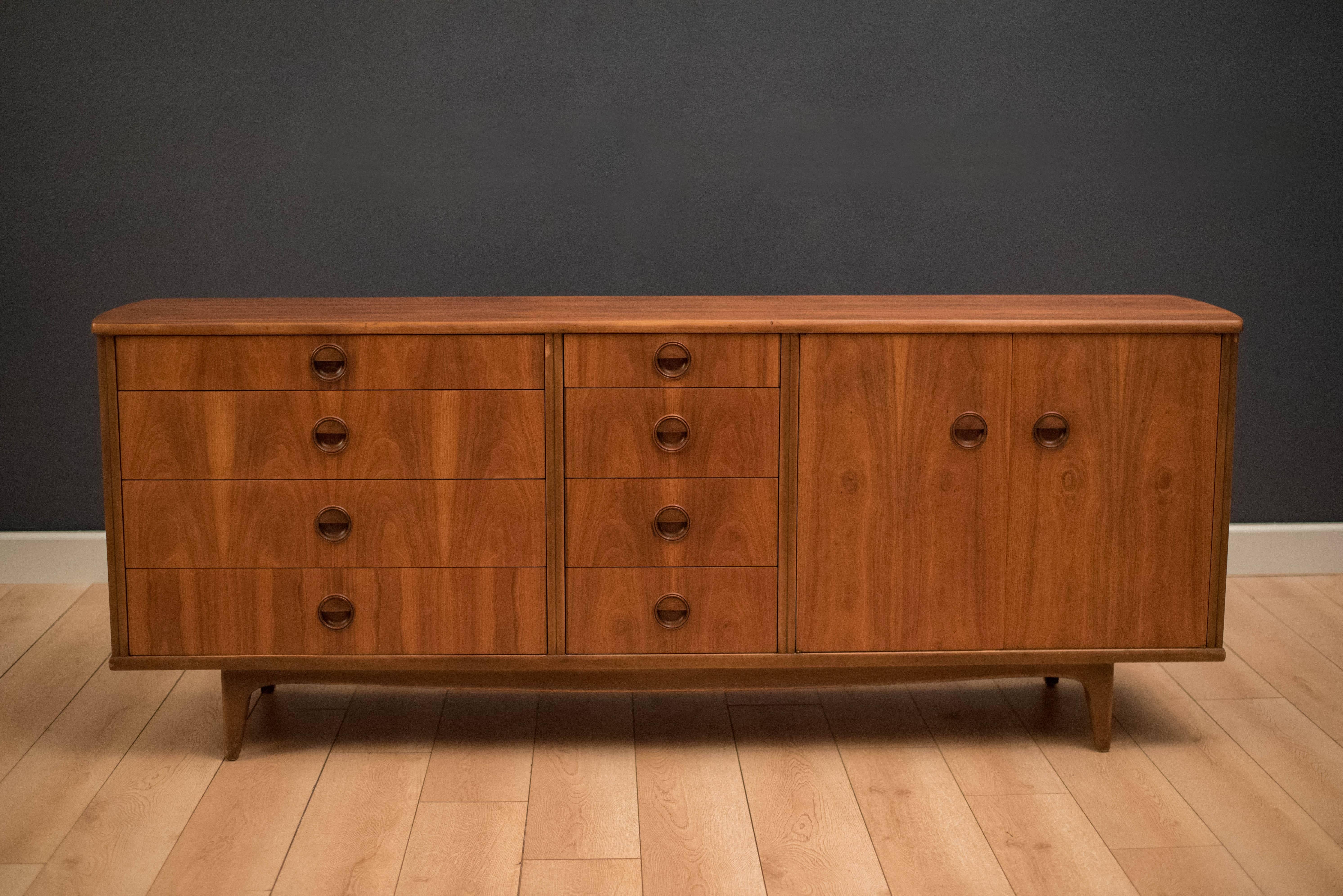 Mid century extra long dresser in walnut made by Langstrom Furniture. This piece is equipped with eight dovetailed drawers and open storage space with one adjustable shelf.  This versatile piece can function as a storage credenza or dining room