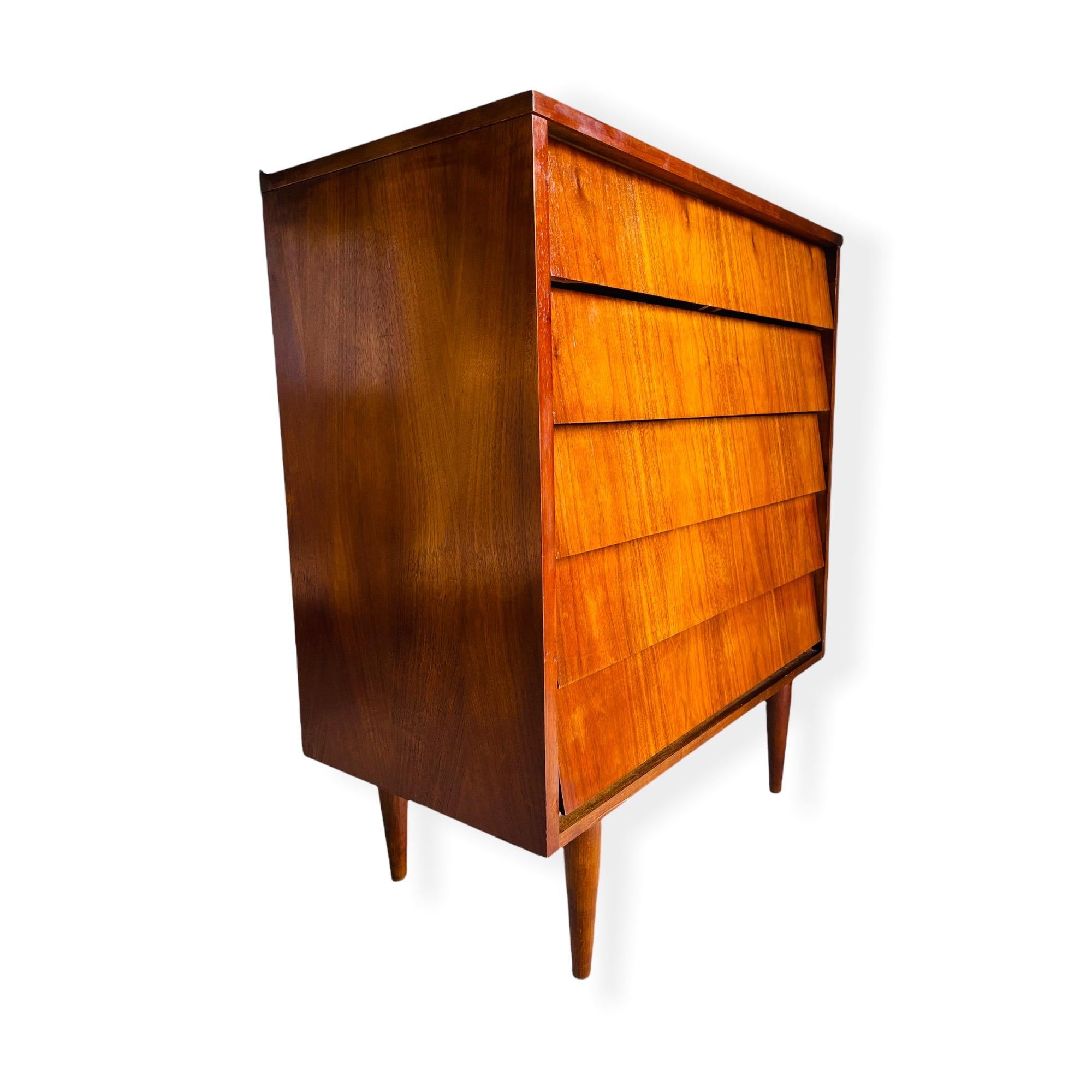 Here is a beautiful Mid-Century Modern tall/highboy dresser in Walnut with 5 drawers. This dresser is in good vintage condition with normal wear consistent with age and use. 

Measures: W 34” x D 18 x H 41”.