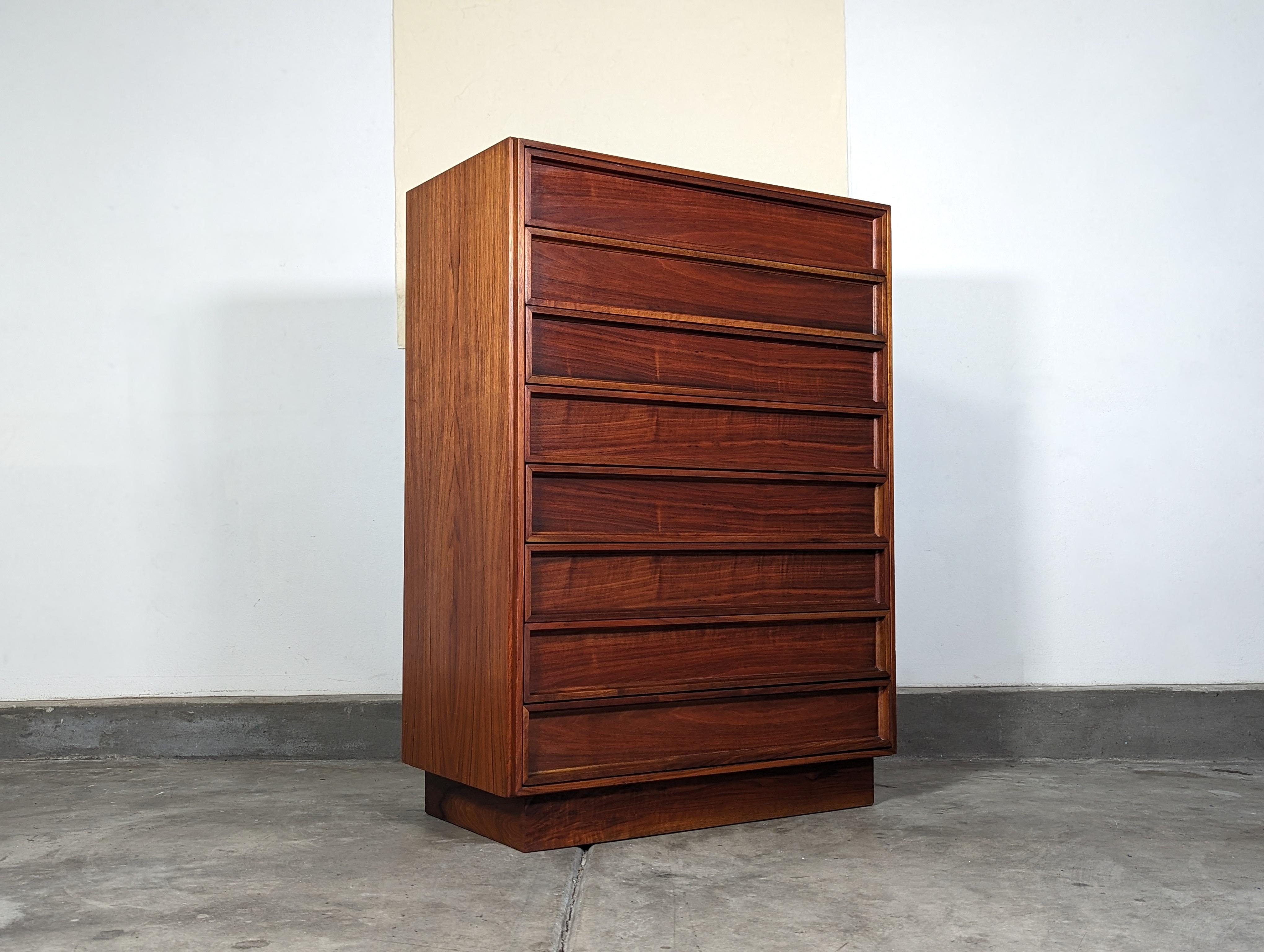 Introducing a distinguished piece of mid-century modern artistry, this vintage tallboy dresser by John Keal for Brown Saltman defines the iconic 1960s style with its sleek design and timeless appeal. Measuring 36