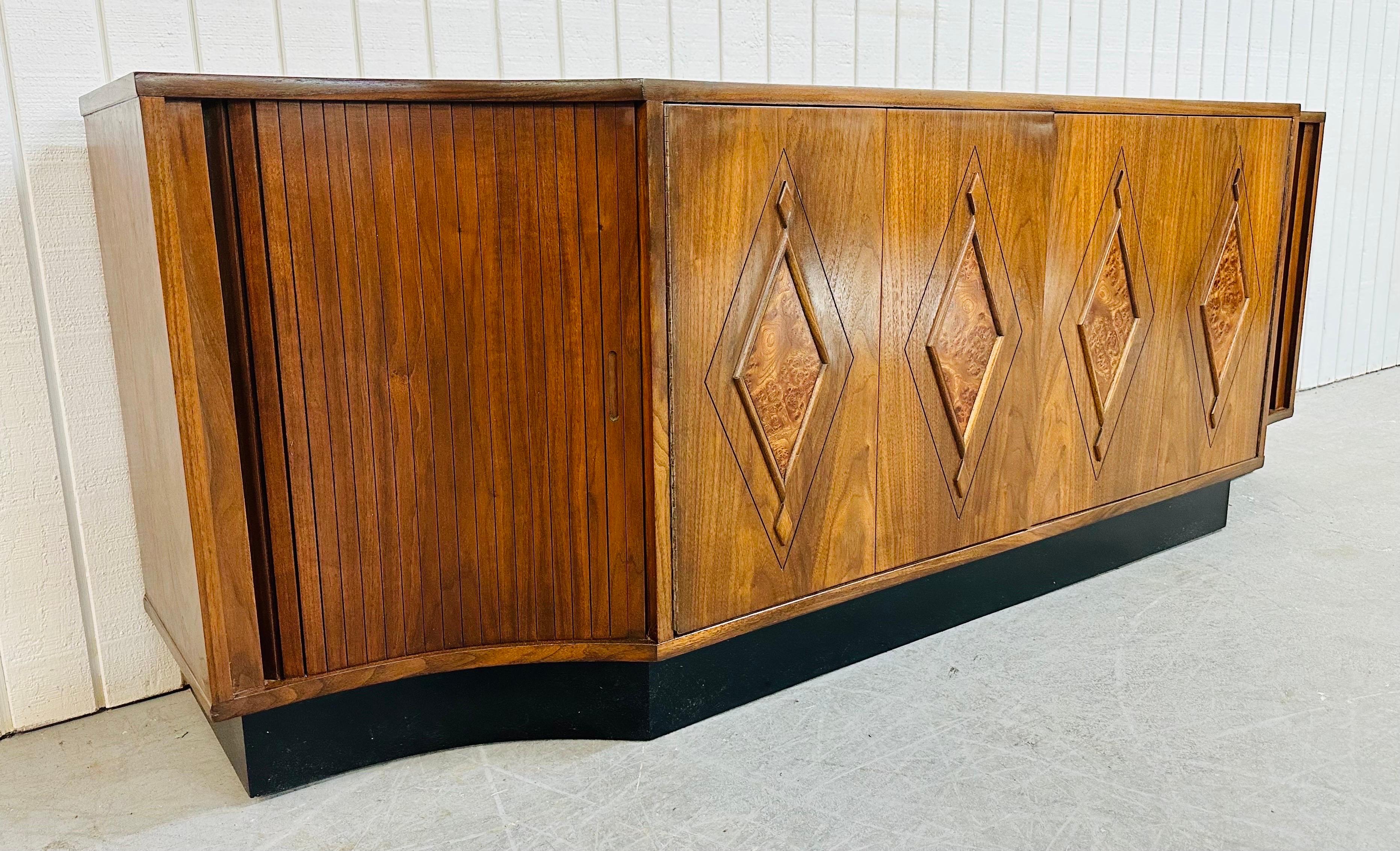 This listing is for a Mid-Century Modern Walnut Tambour Door Sideboard. Featuring a 84” L walnut top, center doors that push open to a shelf, sliding tambour doors on each end that open up to more storage space, a beautiful burled walnut diamond