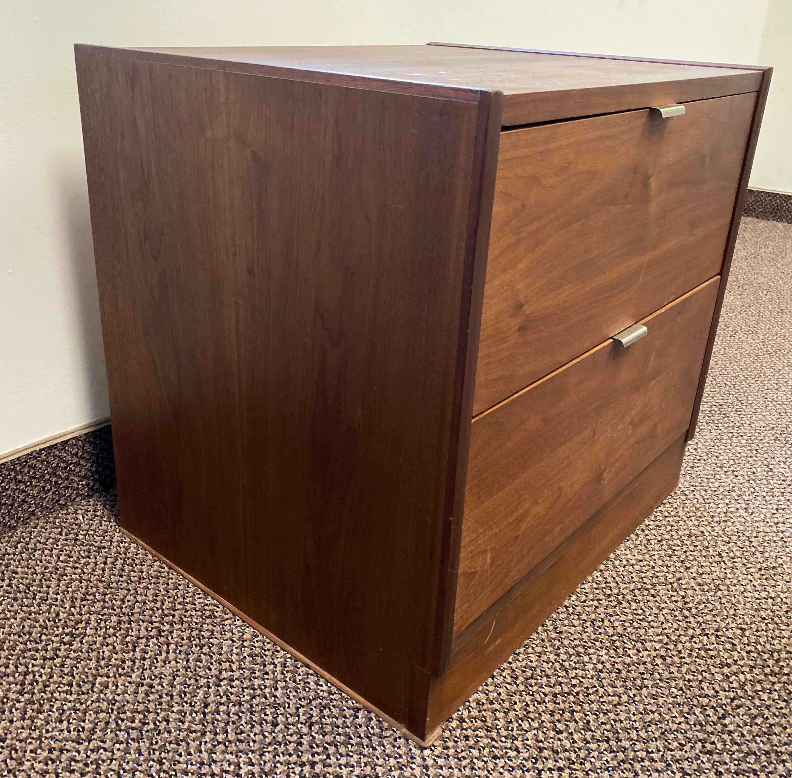 Mid-Century Modern walnut two-drawer cabinet. Walnut cabinet with two drawers and silver edge pulls.