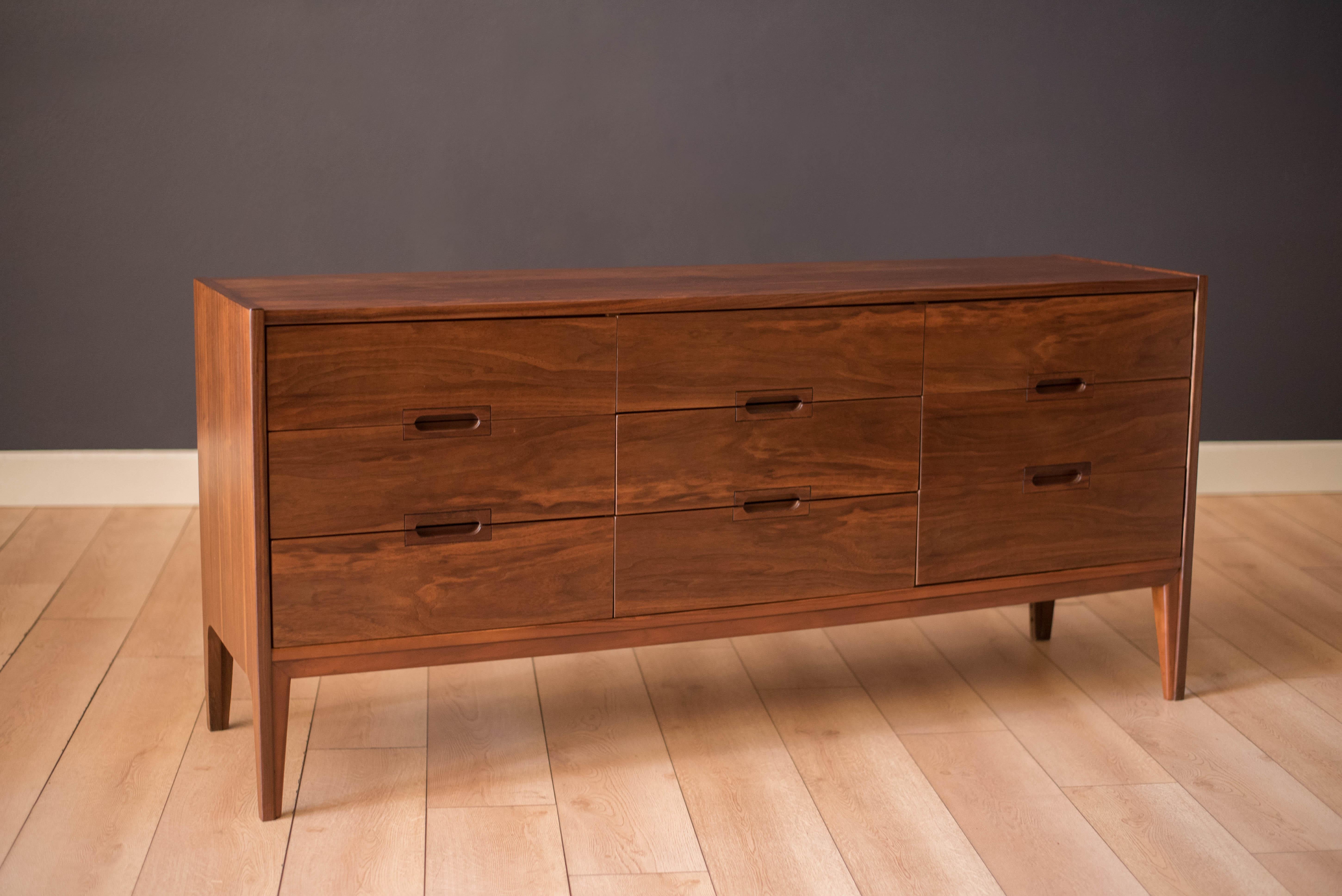 Vintage nine drawer dresser in walnut manufactured by United Furniture Corporation, c. 1960's. This piece features recessed handles and dovetailed drawer construction with deep storage space.