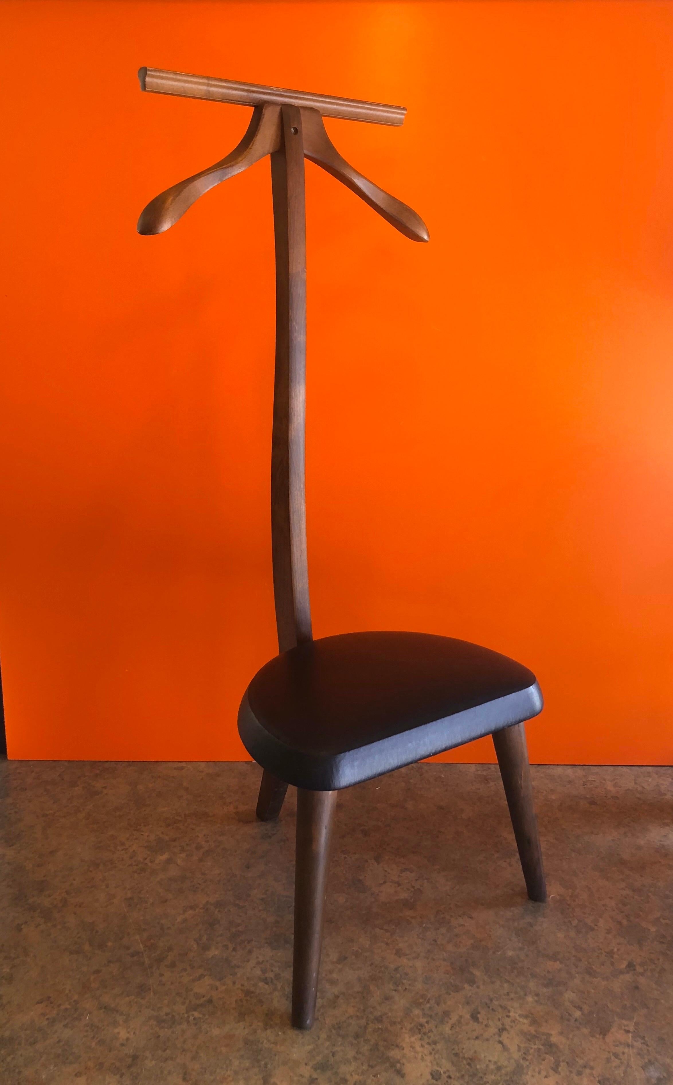 Mid-Century Modern walnut valet stand with black Naugahyde seat by Marshall Furniture, Co., circa 1960s. Simple design with clean leans in very good vintage condition.