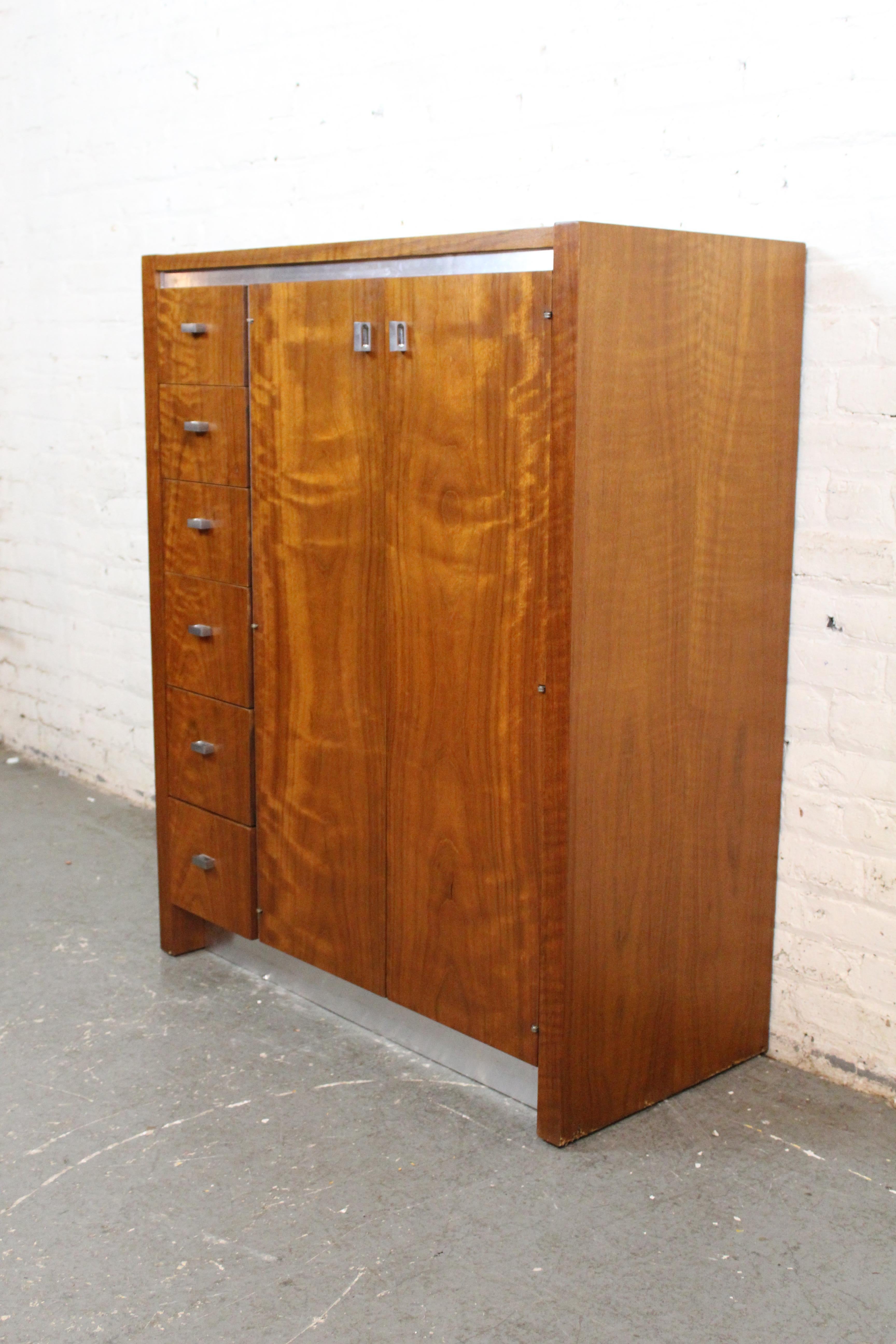 Découvrez l'aspect pratique et luxueux du mobilier moderne américain du milieu du siècle avec cette armoire rare et exquise conçue par Jack Cartwright pour Founders Furniture. Réalisé en noyer chaud avec des accents chromés élégants, ce design