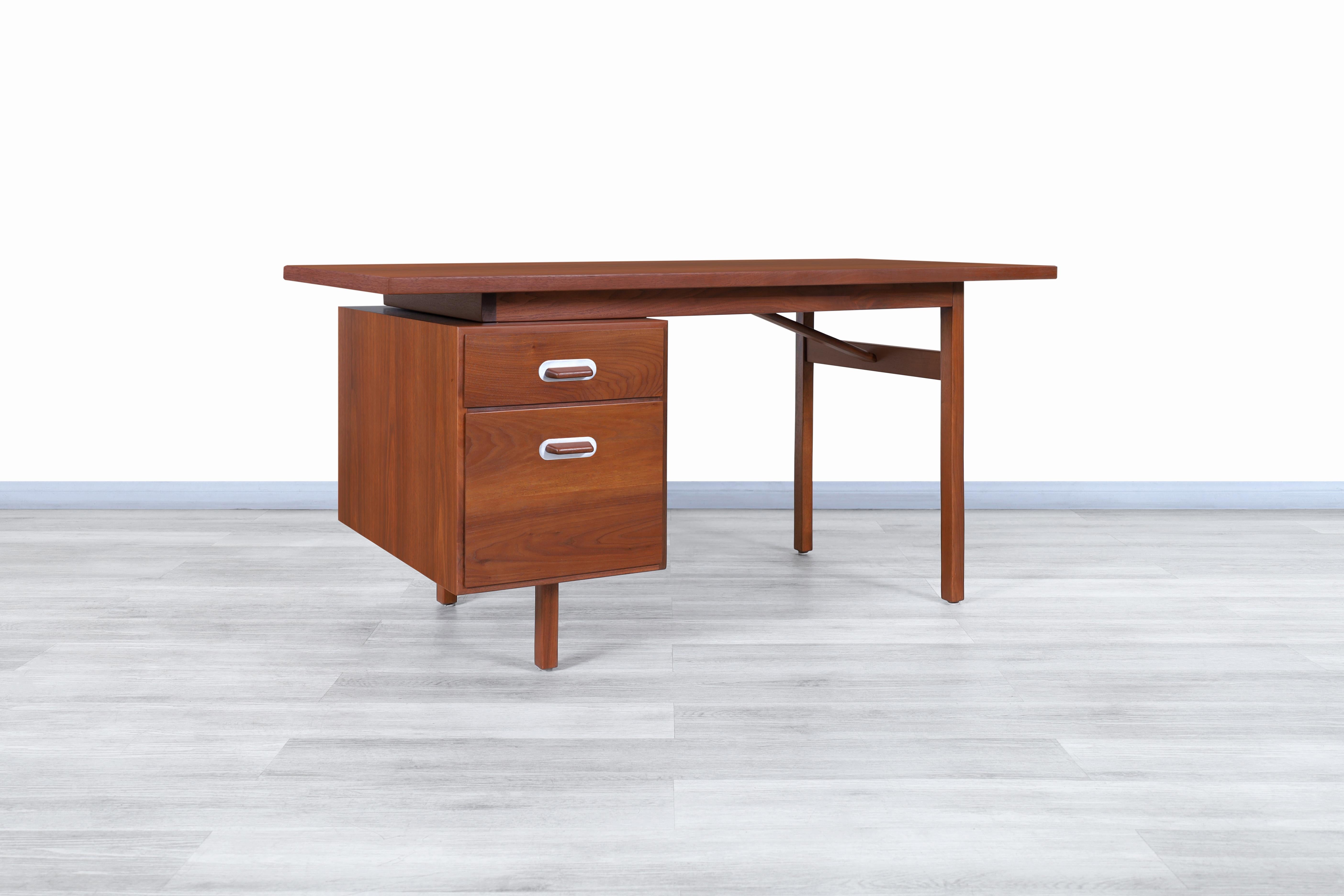 Exceptional Mid-Century Modern walnut writing desk by Jens Risom and manufactured in the United States, circa 1950s. This desk has a conservative design but is highly functional, which stands out thanks to the elegant walnut wood used for its