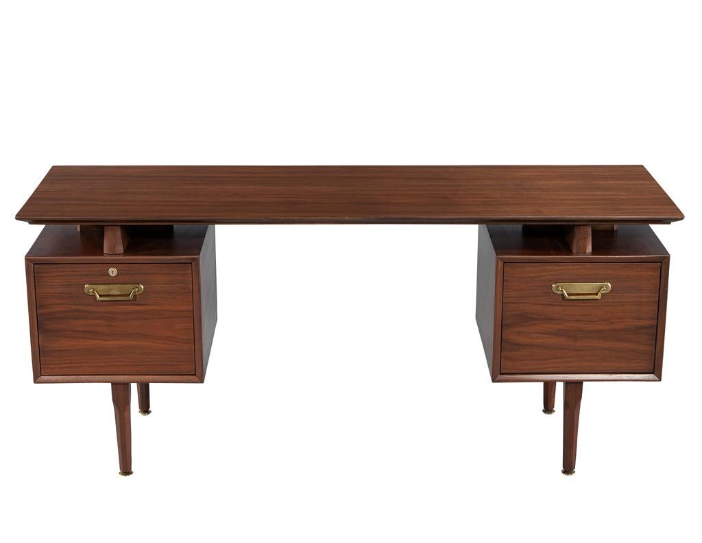 Dieser atemberaubende moderne Schreibtisch aus der Mitte des Jahrhunderts, der um 1970 in den USA hergestellt wurde, ist eine zeitlose Ergänzung für jedes Heimbüro oder jeden kreativen Raum. Mit seinem schönen Nussbaumholz und den originalen