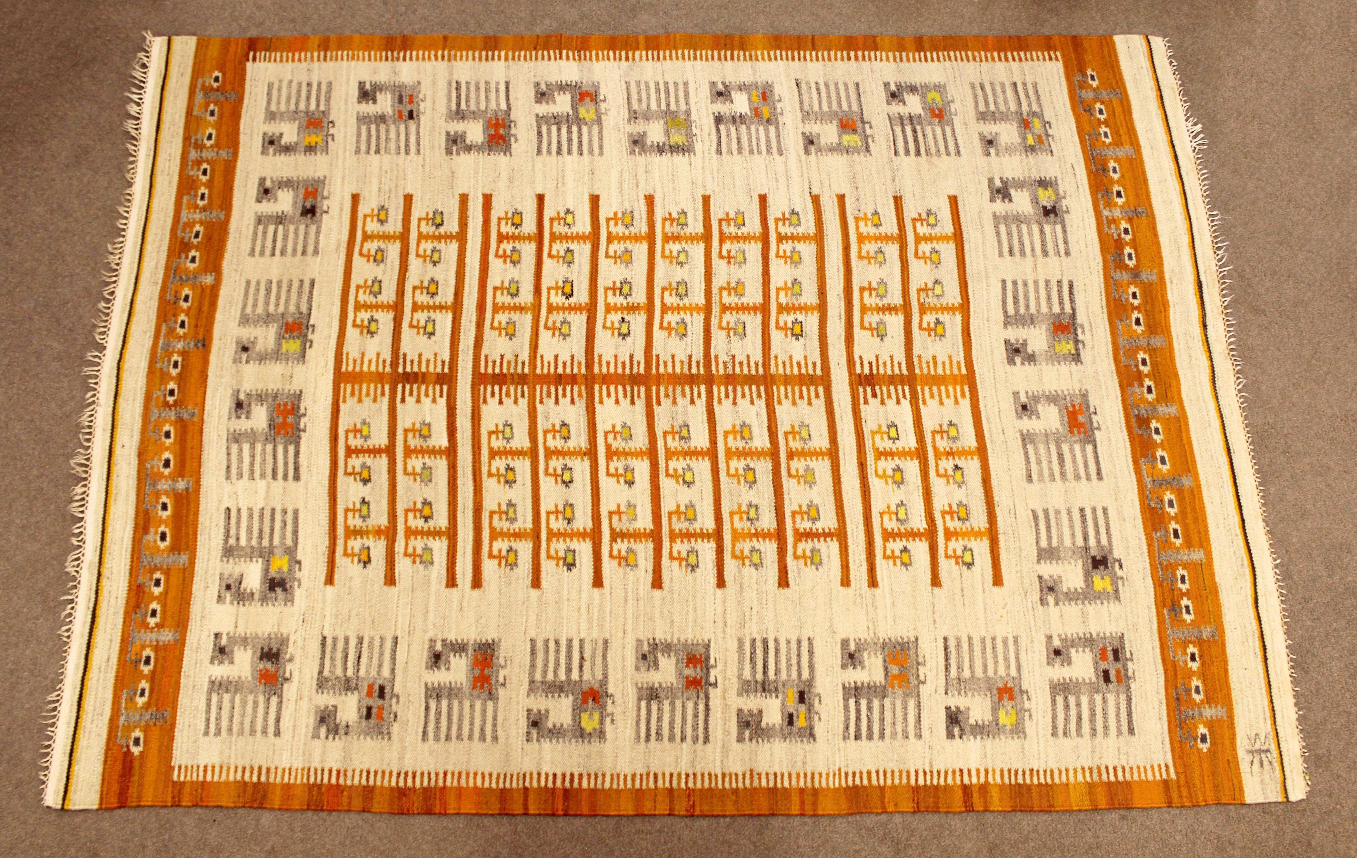 For your consideration is a magnificent, rectangular, flat-weave wool, area rug with an orange pattern, by the Polish company Wanda Krakow, circa the 1960s. In very good condition. The dimensions are 64