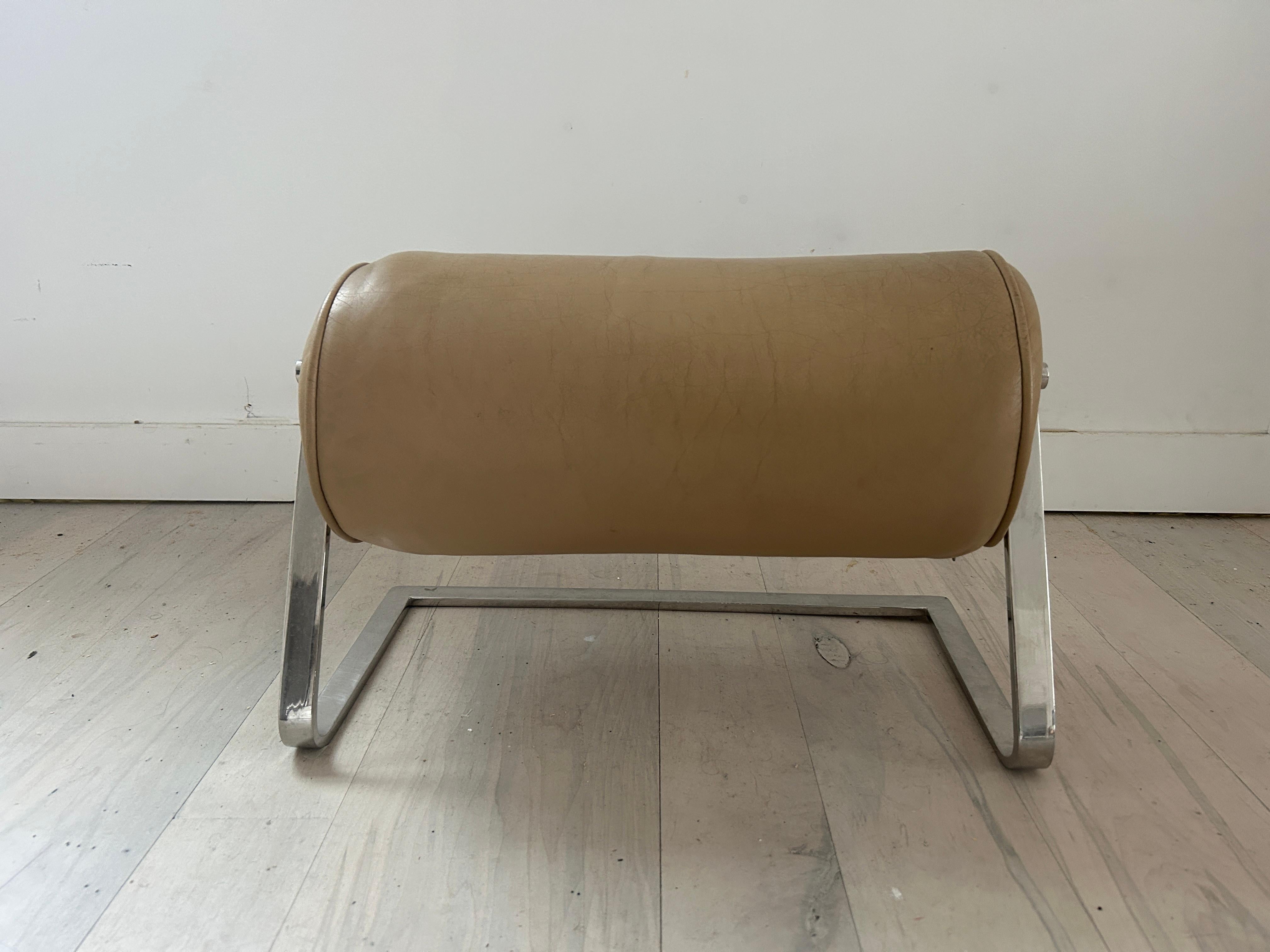 Mid-Century Modern Ward Bennett low tan leather chrome footrest stool pouf ottoman No. 1059. Great Design by Ward Bennett - Rare Foot rest made for Brickel Associates USA. Solid metal chrome frame with tan leather upholstery with Piping. Made Circa