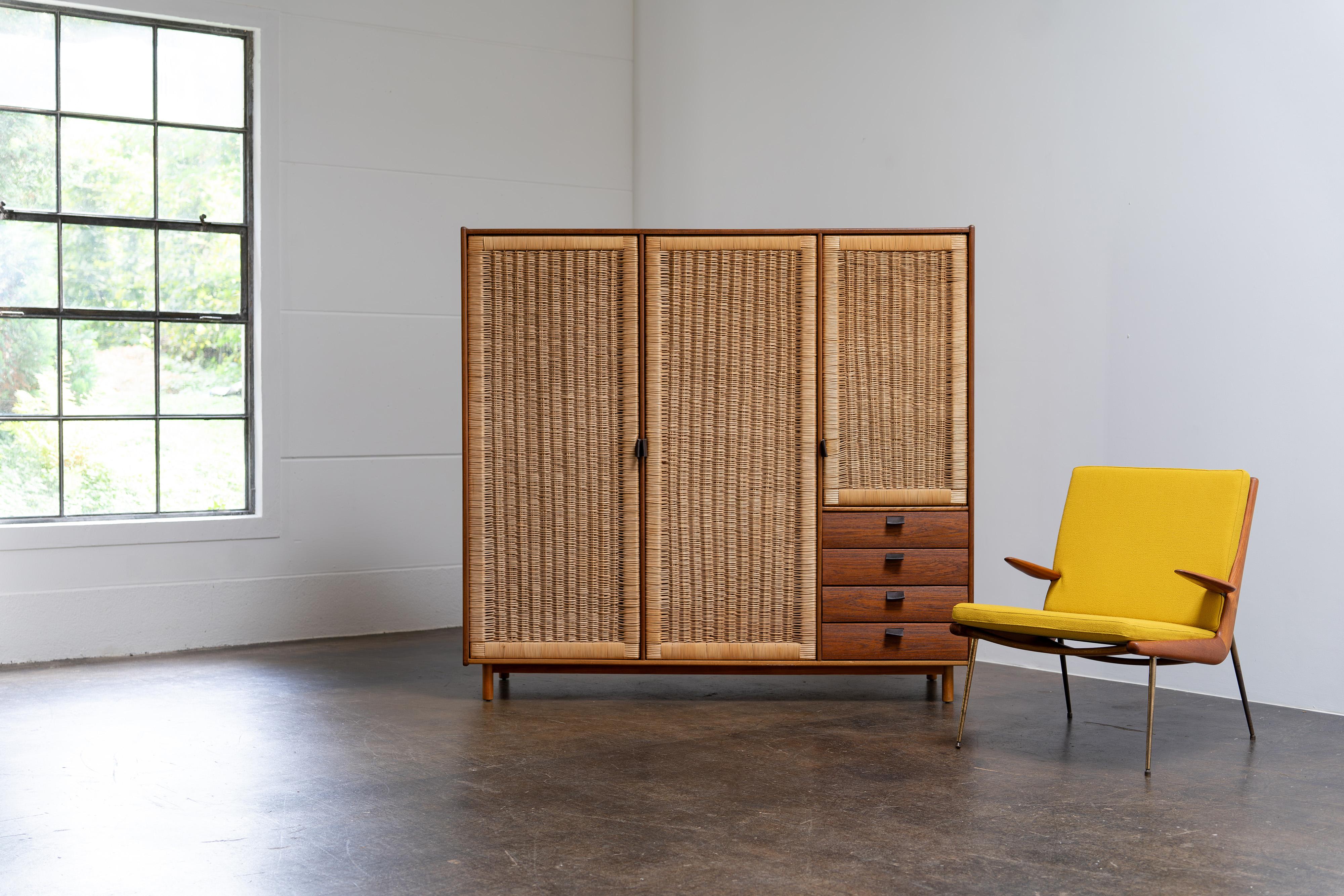 Seltener dreitüriger Kleiderschrank von Sebastian Muggenthaler aus den 1960er Jahren. Dieses exquisite Stück besticht durch seine raffinierte Materialkombination: ein Korpus aus Teakholz, Türen aus Rattanrohr, ein Rahmen aus Buchenholz und elegante