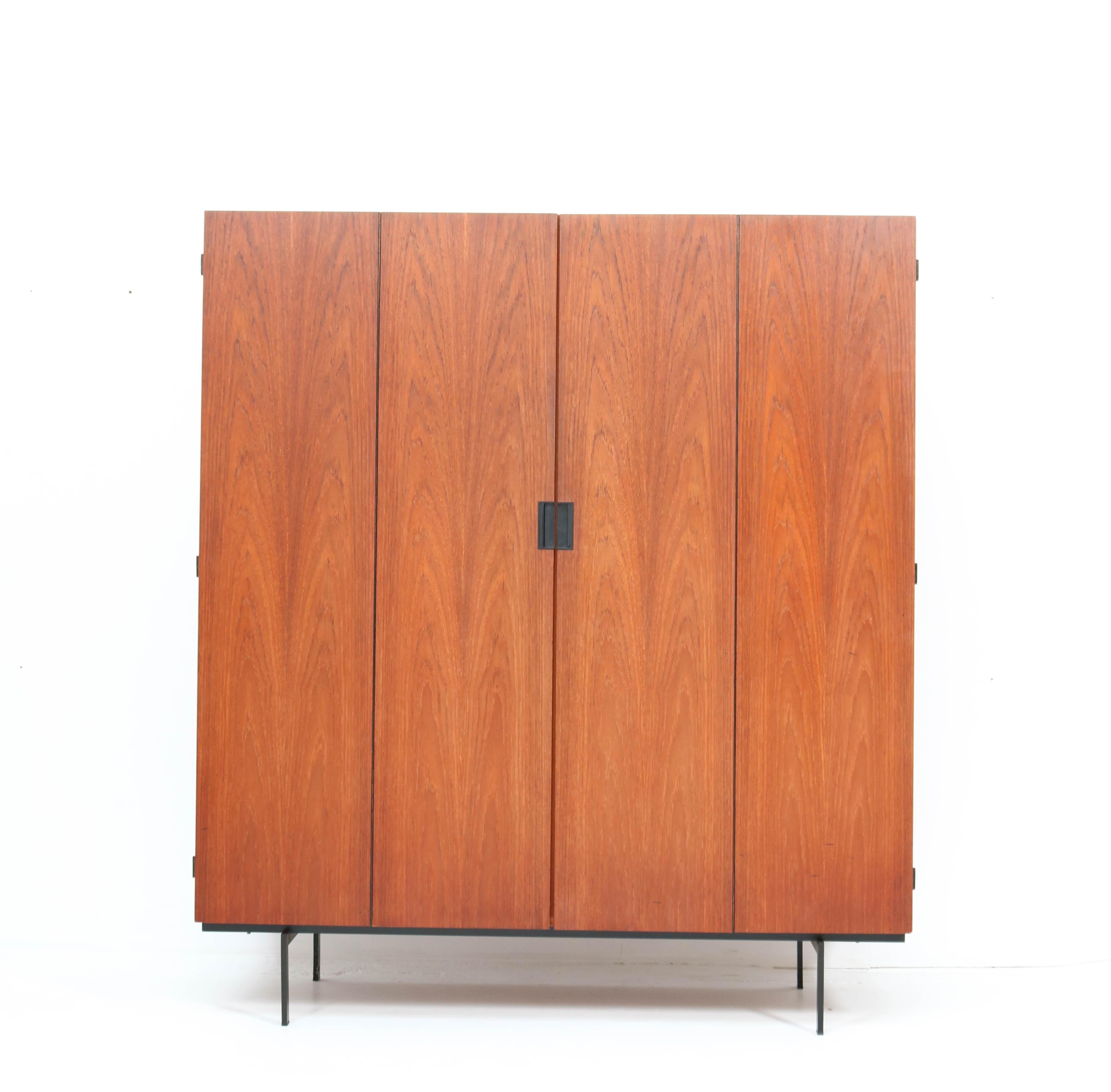 Magnificent Mid-Century Modern KU14 Japanese Series armoire or wardrobe.
Design by Cees Braakman for Pastoe.
Striking Dutch design from the 1960s.
Original teak veneered wood on black lacquered metal feet.
This wonderful piece of furniture can