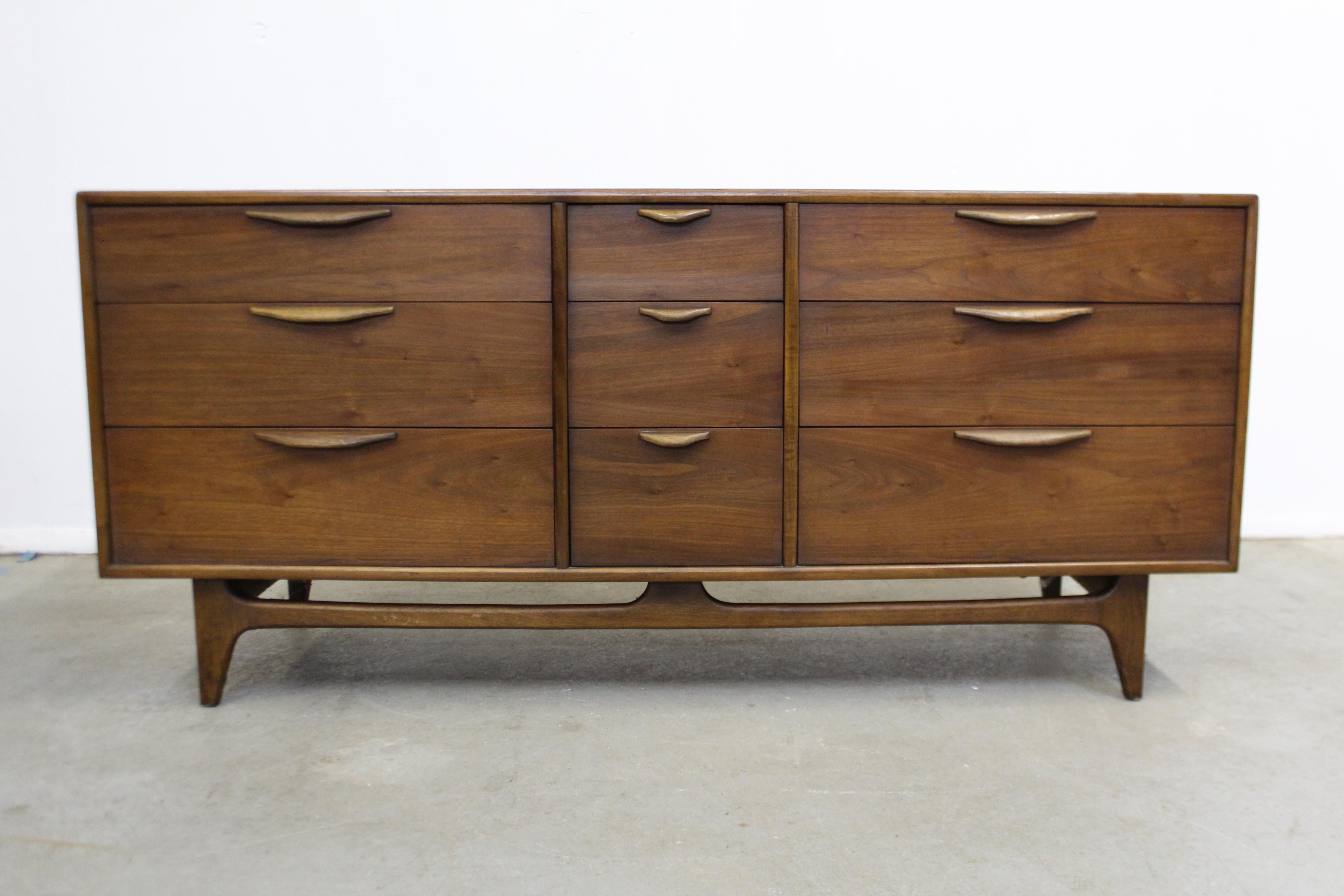 Offered is an excellent example of American Mid-Century Modern design; a walnut triple dresser designed by Warren Church for Lane furniture's 'Perception' line. Features 9 dovetailed drawers with sculpted pulls. It is in excellent condition for its