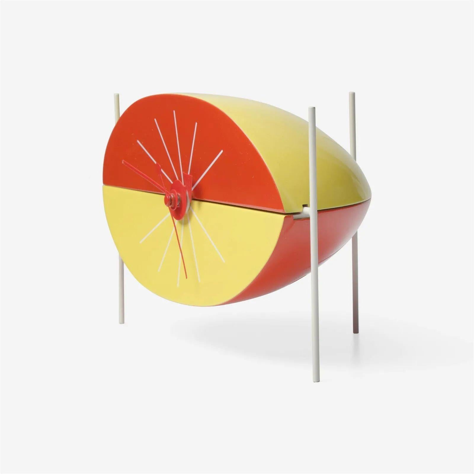 George Nelson (American, 1908-1986) Table Clock for Howard Miller, Vitra Design Museum, Poland/Germany, designed 1949-1954
 
Watermelon clock with red and yellow lacquered wood body, red hands and applied Vitra Design Museum labels having