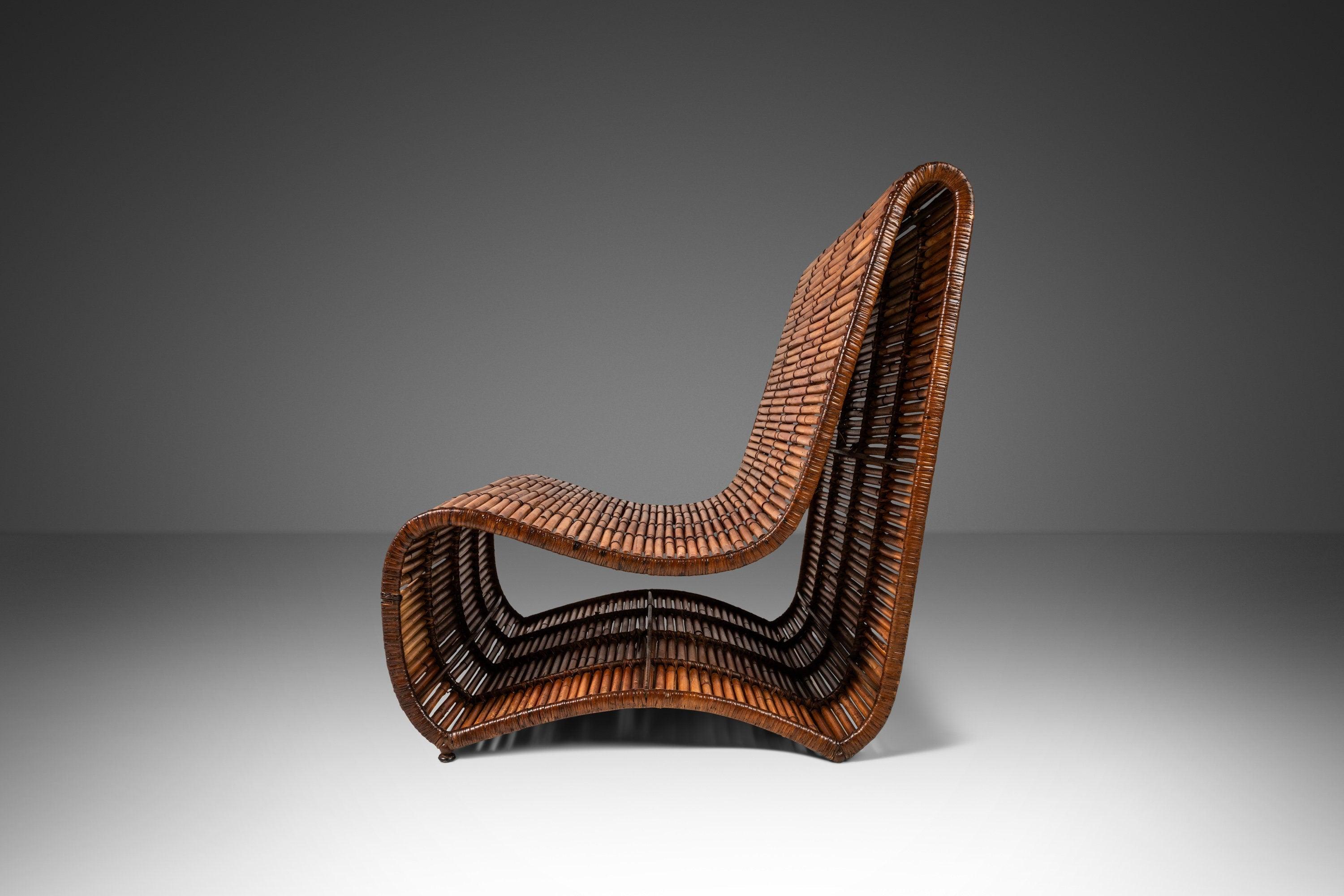 Designed by the incomparable Danny Ho Fong in 1970 this fascinating larger than life slipper chair is arguably one of his greatest creations. A pioneer in the use of organic materials like rattan and bamboo this 