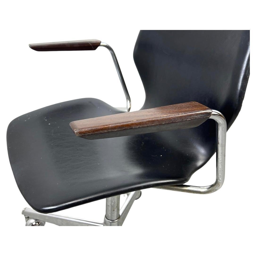 Mid-Century Modern Westnofa black vinyl office chair minimalist. Bent wood seat adjustable chrome base with casters. Minimalist teak arm rests chrome and teak. Very clean chair. Labeled Under seat. Made in Norway. Very clean chair. Seat height is