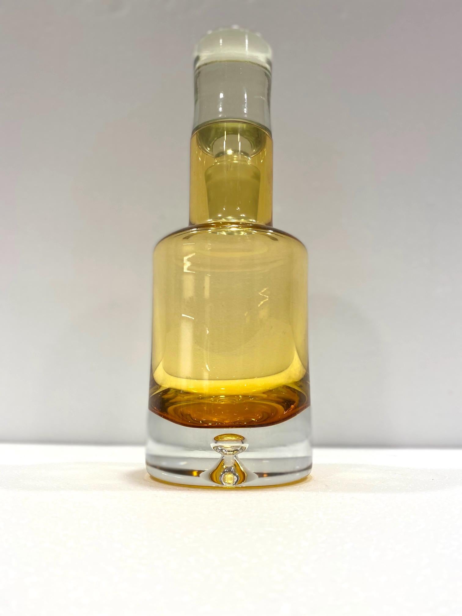 Vintage Scandinavian Modern spirits decanter in blown yellow glass. The decanter is made of heavyset chunky glass with a streamline form. It features a clear glass base with large center bubble detail and gradient glass moving from hues of amber