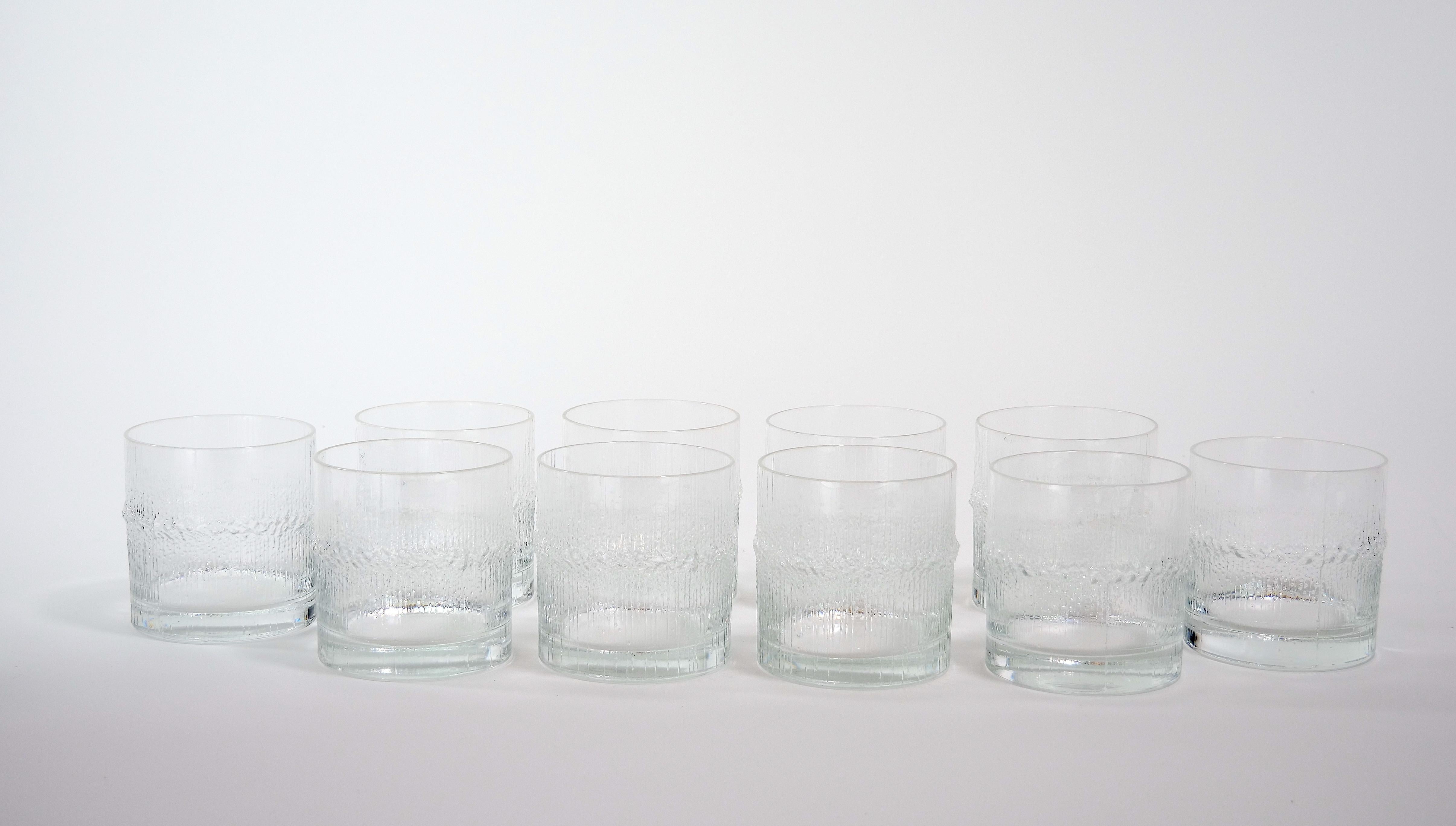 Mid-Century Modern beautiful whiskey and drinks barware / tableware service for 11 people. Each features an exterior particle ice crush design detail and resting on a flat round base. Each glass measures 3.5 inches high and 3.25 inches diameter.
   