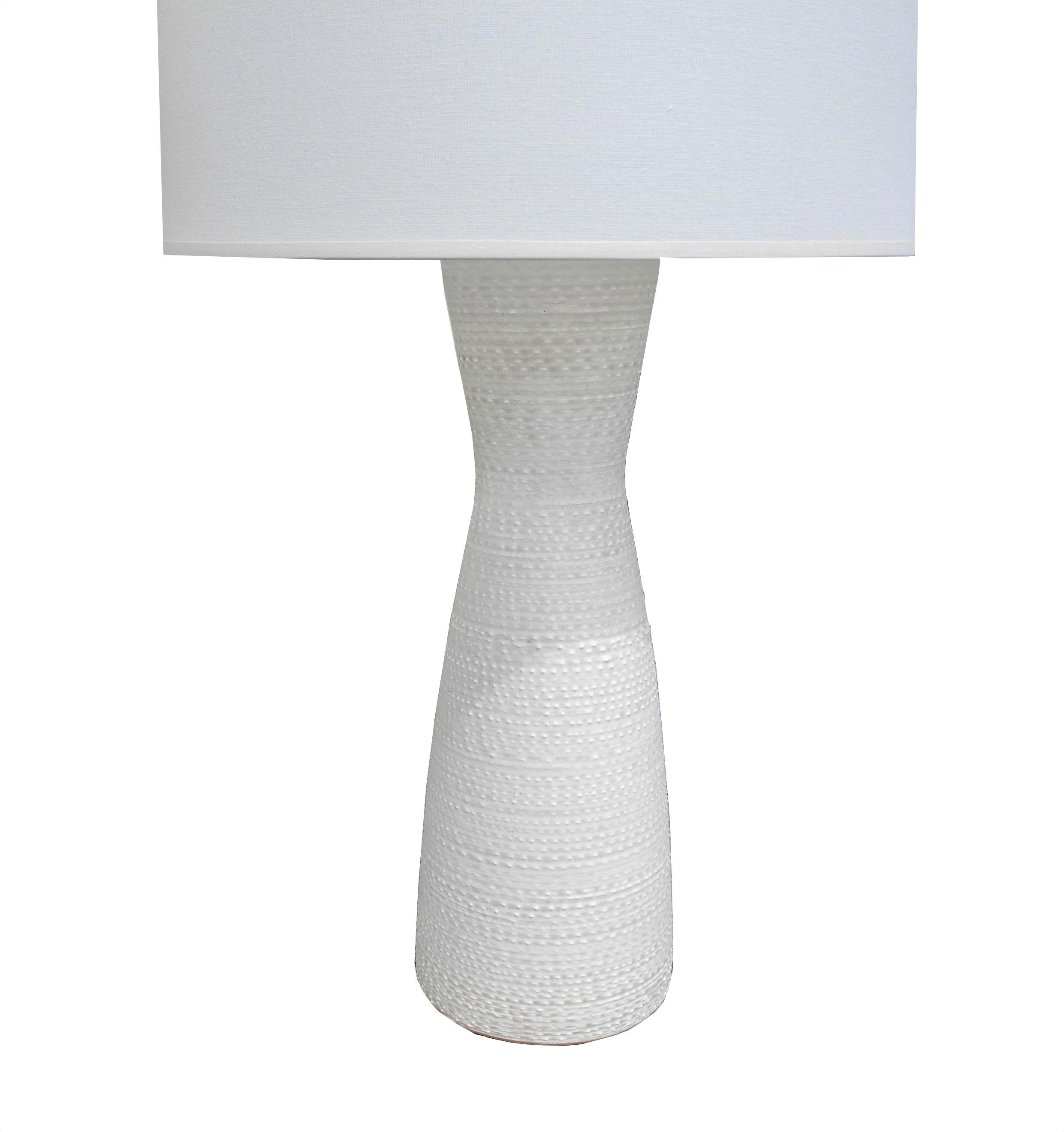 Design Technics of New York was a ceramic lamp company who hired talented artists to create their inventory.
This modern lamp from the 1960s is slightly off white. There are no chips in the pottery and the lamp has been rewired with a silk wrap