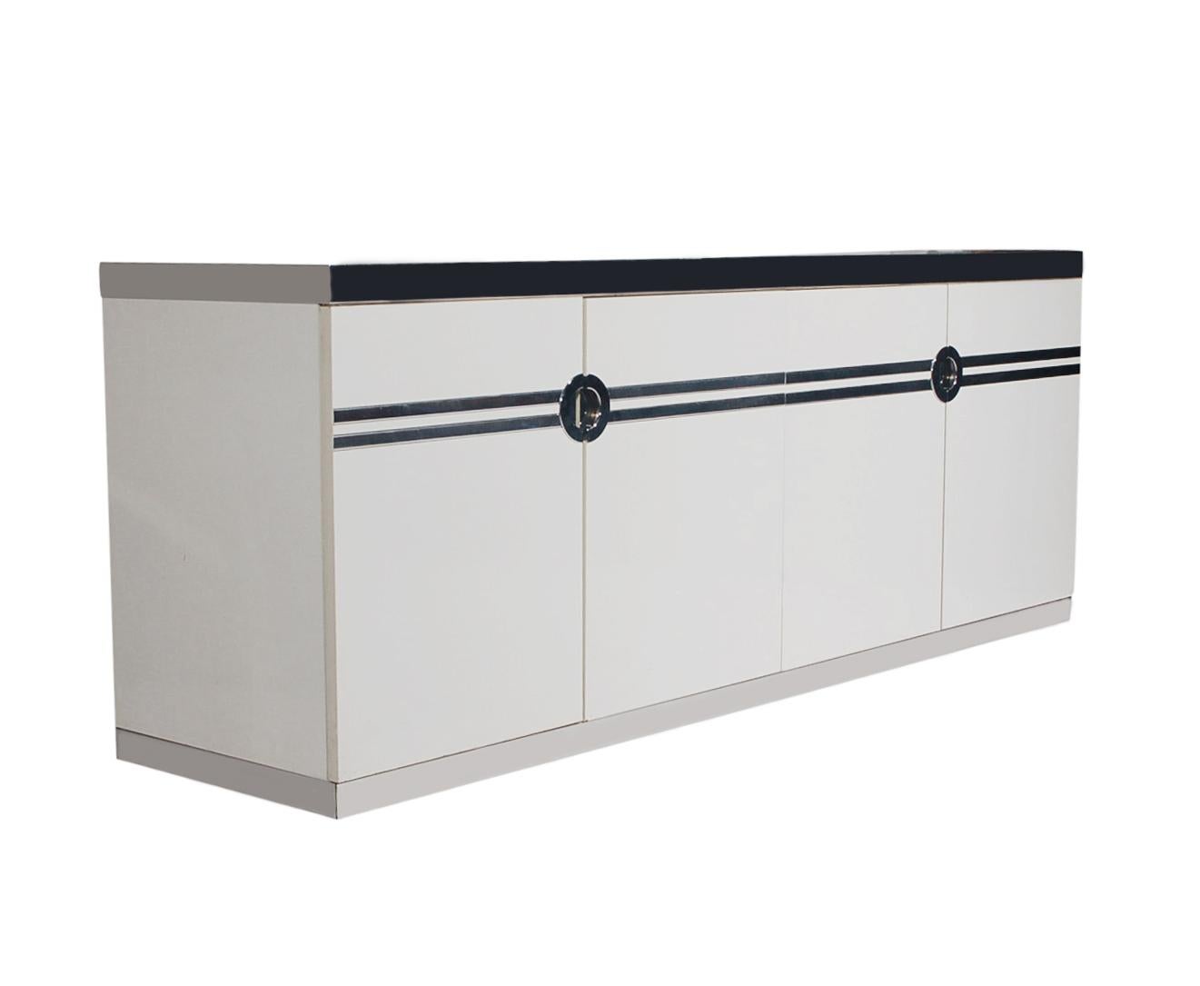 A sleek modern dresser or credenza designed by Pierre Cardin in the 1970s and produced in France. It features a white lacquer finish with polished steel trim in a Classic Art Deco design. It has 6 large interior pullout / pull-out drawers.