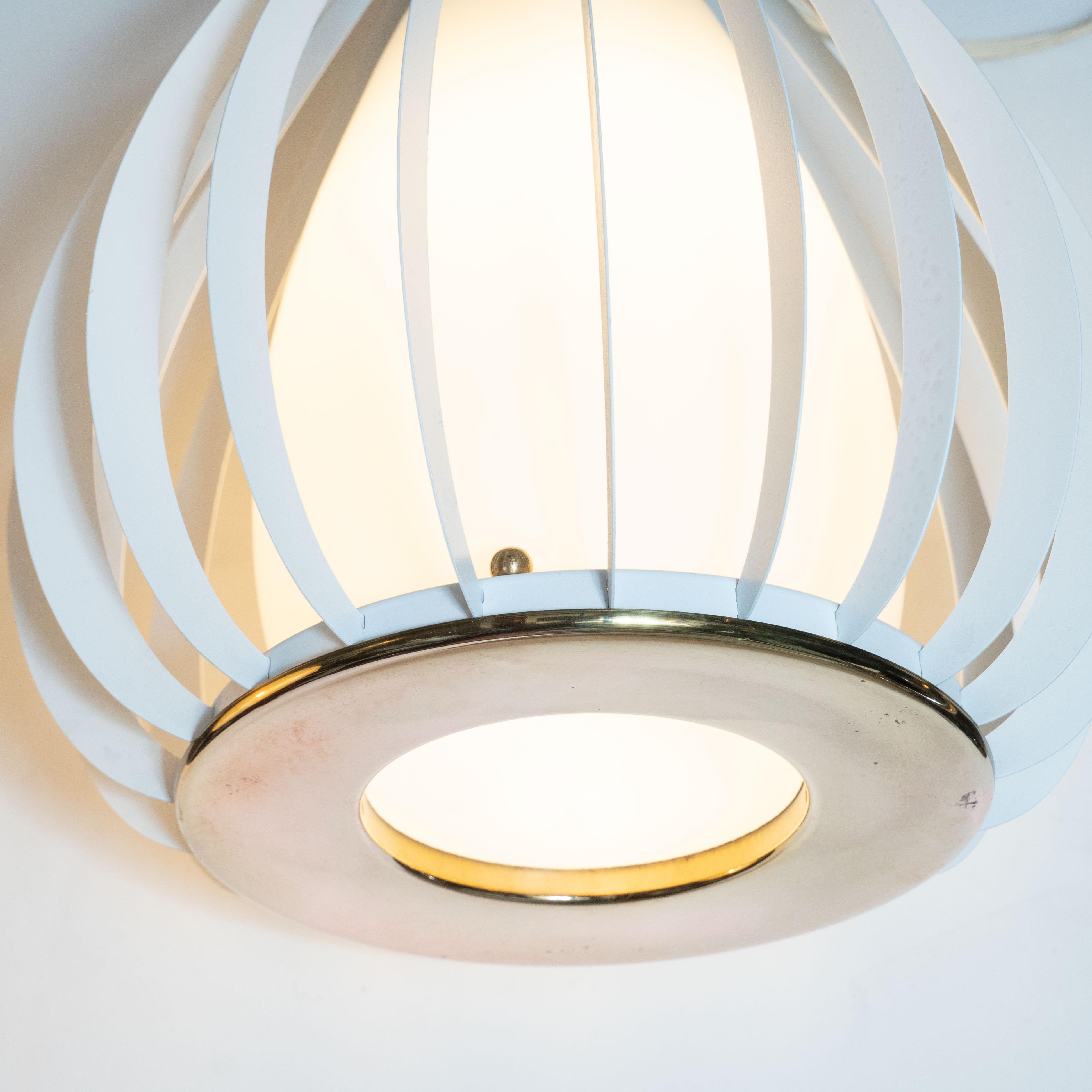 This refined and graphic Mid-Century Modern lantern chandelier was realized in Italy, circa 1960. It features an amorphic ovoid form shade in frosted glass that rests in between two circular brass supports with cutout centers. An abundance of
