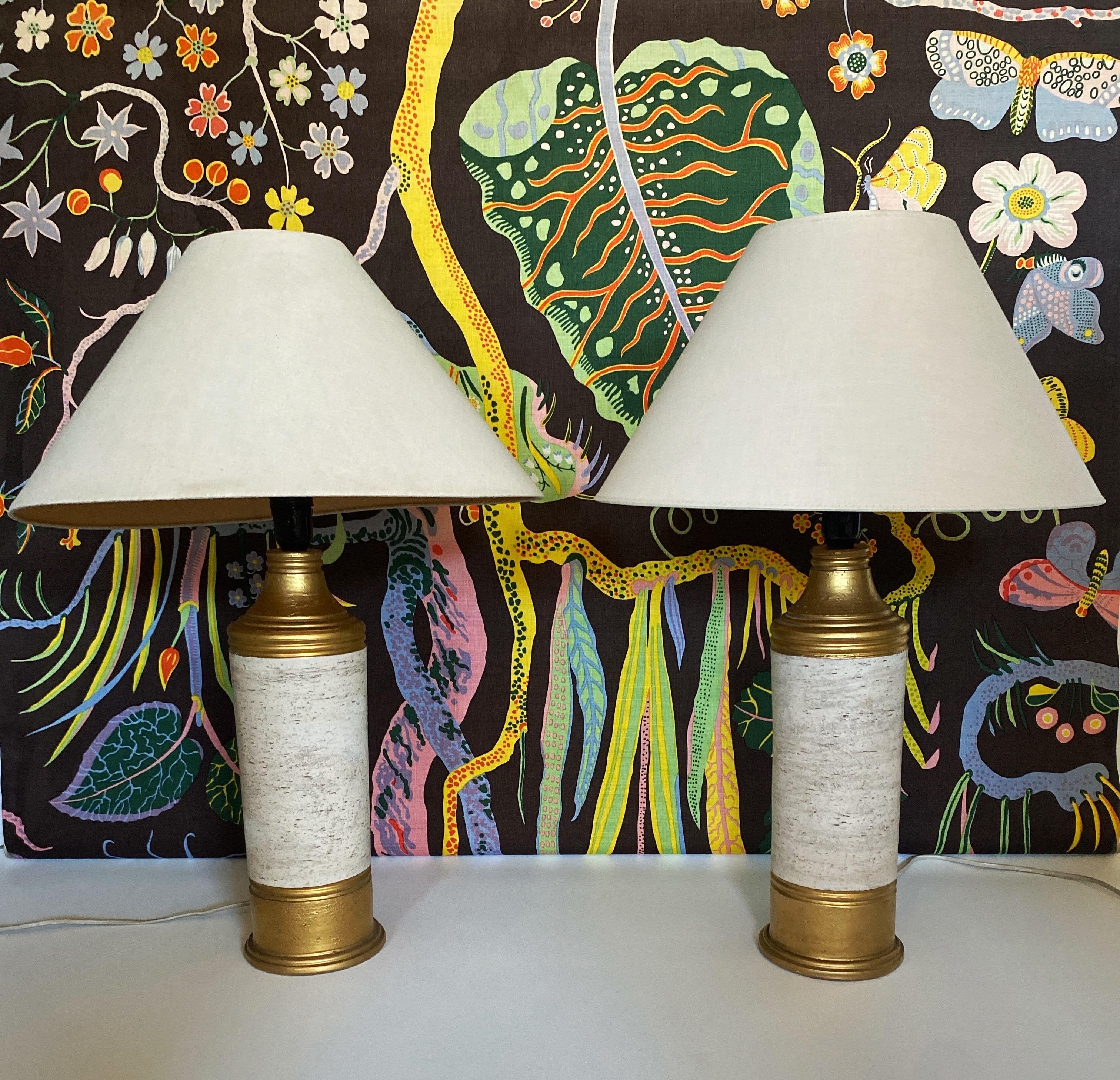 This stunning pair of white ceramic table lamps was designed by Bitossi for Bergboms, featuring a striking contrast between the rough chamotte-textured glaze and the luxurious 22-karat gold glazed accents on the upper and lower sections.

Crafted in
