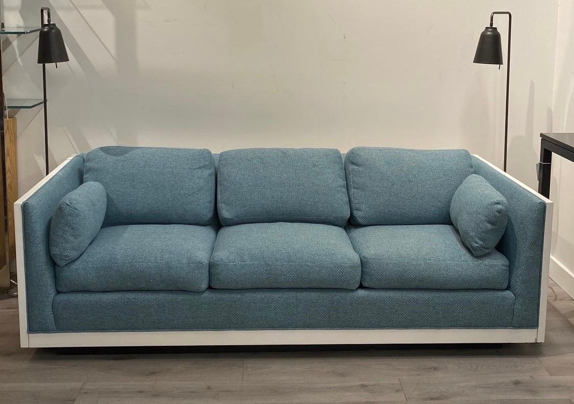 Gorgeous Mid-Century Modern sofa newly lacquered in white and new reupholstered in a luxurious blue fabric. All dimensions are below and arm height is 26